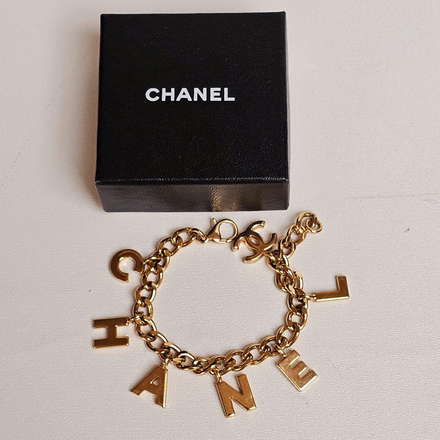 Chanel Bracelet à breloques logo en or en vente 1