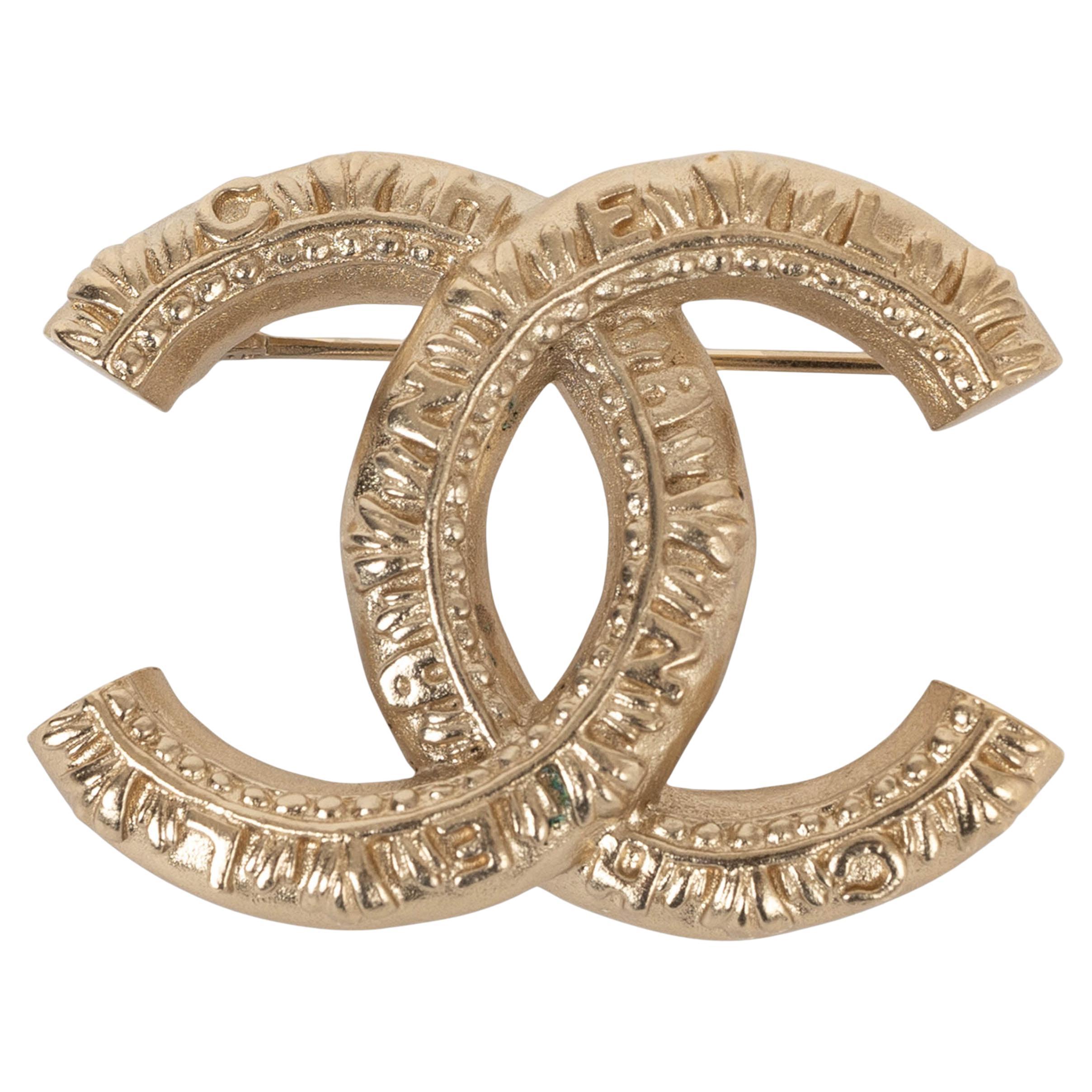 CHANEL gold metal 21A CHATEAU DES DAMES LOGO TEXTURED CC Brooch For Sale