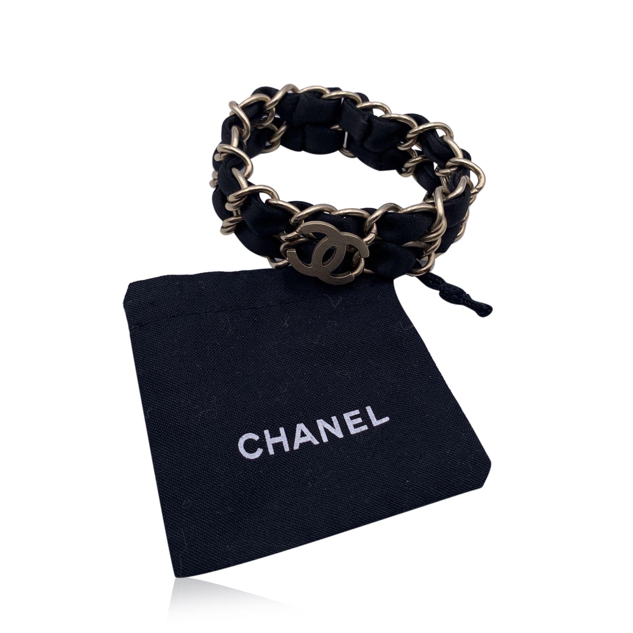 Chanel-Armband mit doppelten goldenen Metallketten und schwarzen, verflochtenen Bändern. CC-Logo-Akzent. Kein Verschluss, so dass man das Armband anziehen muss. Passt bis zu einem Handgelenk von ca. 16,5 cm. Chanel B11 CC P - Made in Italy