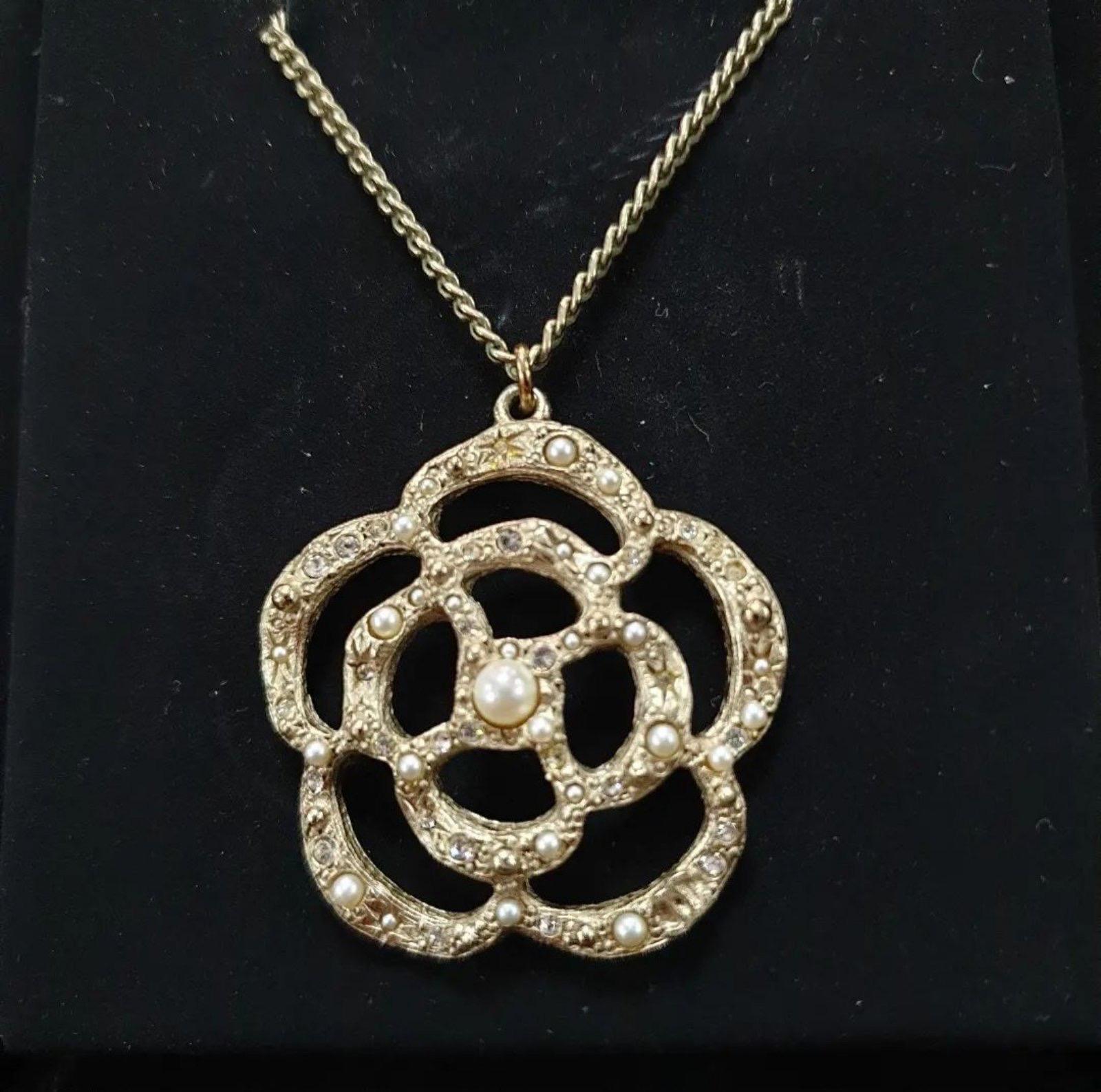  Gorgeous Chanel Gold Metal and Faux Pearl Camellia Pendant Necklace.
 It features goldtone metal in the Camellia flower design and faux pearls set on a lovely goldtone snake chain. 
Very good condition.
Comes with a case.