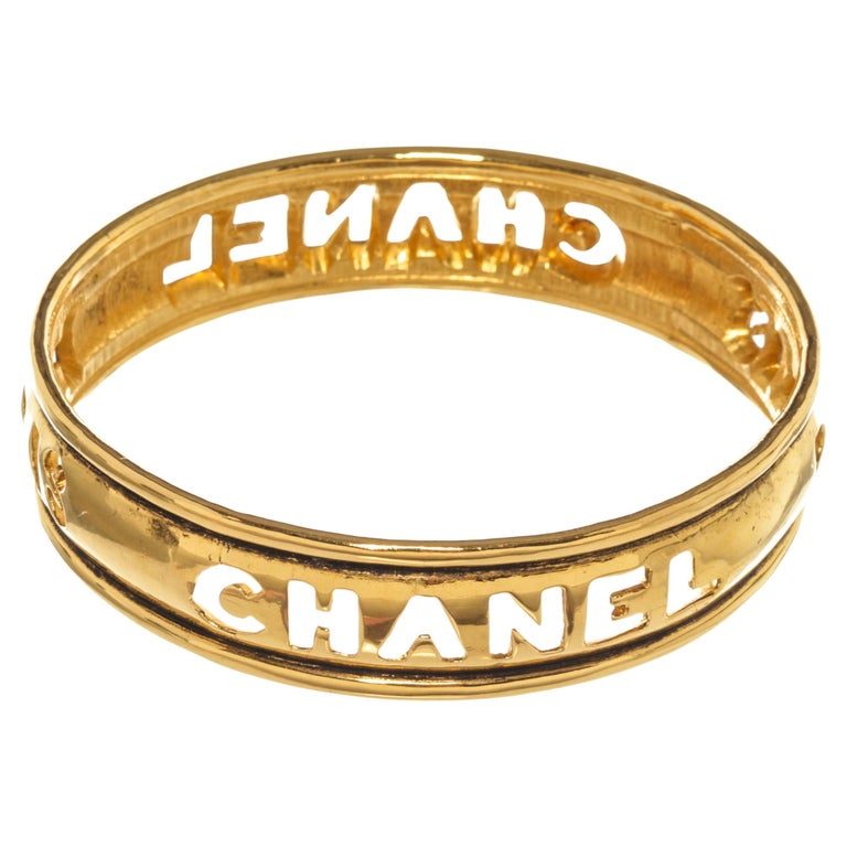 Chanel Gold Metal Cut Out Logo Bangle Bracelet For Sale at 1stDibs