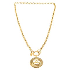 Chanel, collier pendentif rond vintage CC en métal doré