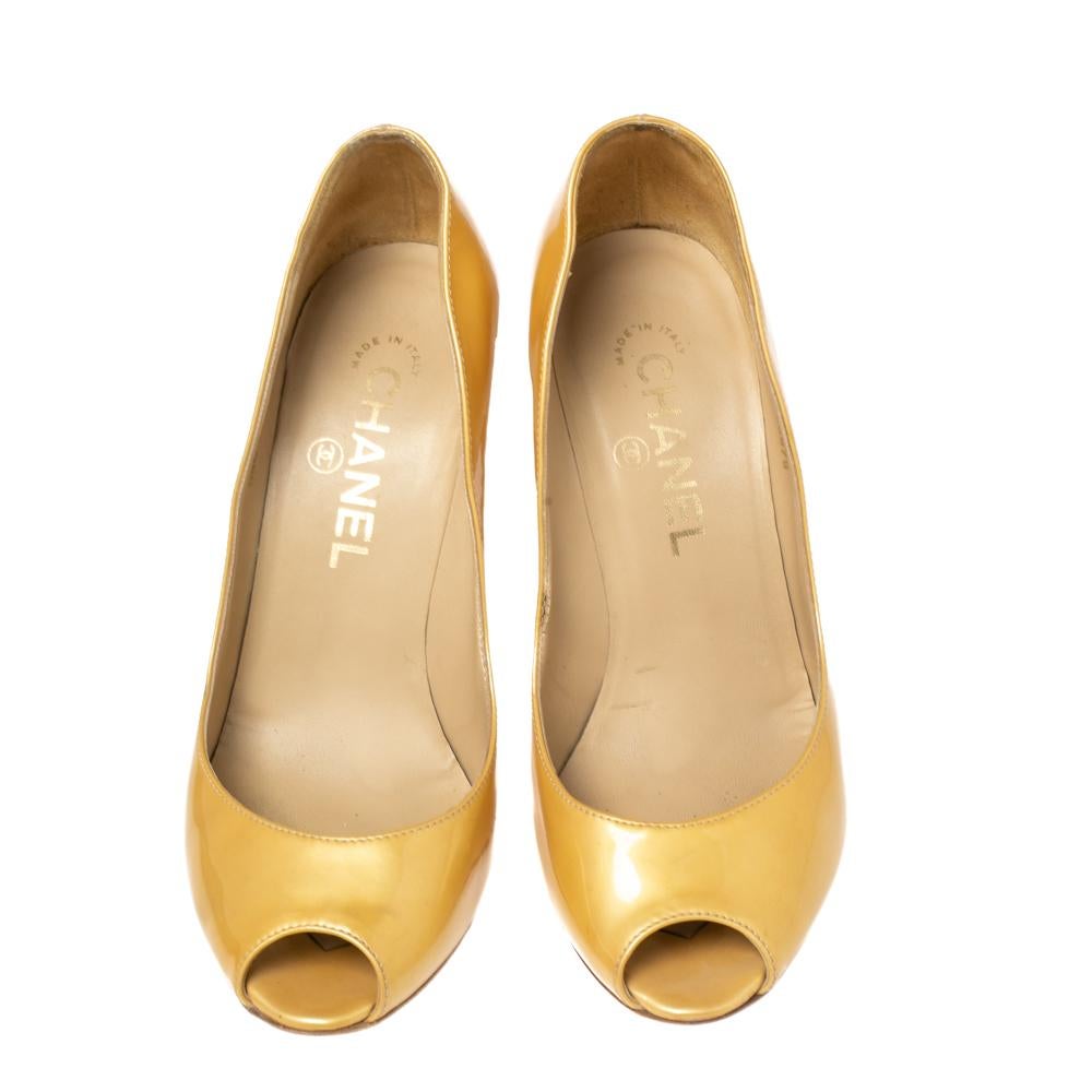 This pair of pumps by Chanel showcases the perfect blend of quality and elegance. Crafted with patent leather, the gold pumps feature peep toes, leather-lined insoles, 10 cm heels, and the CC logo on the counters. They are sure to be a wardrobe