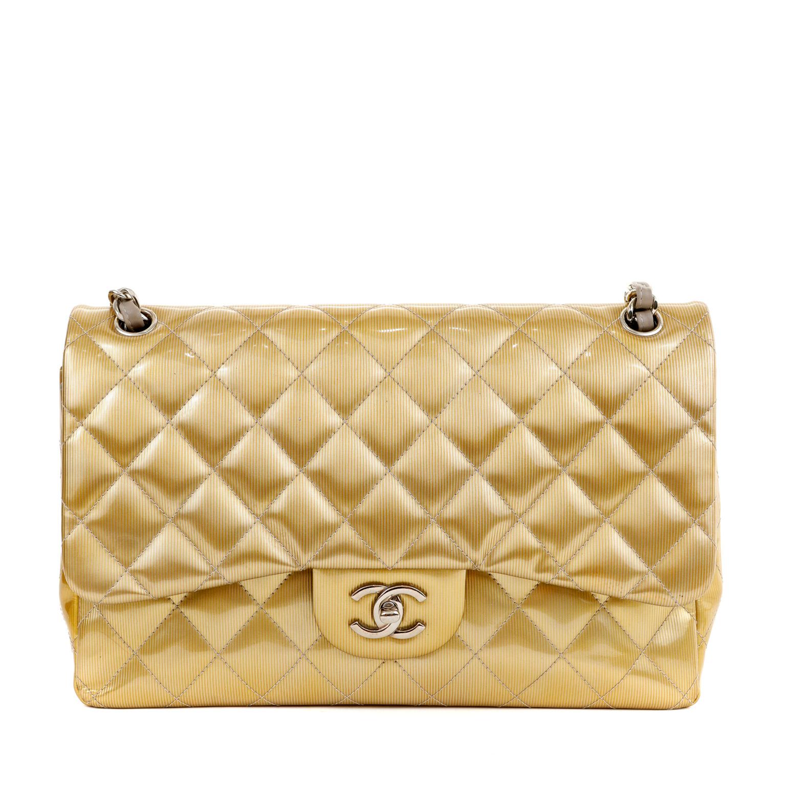 This authentic Chanel Gold Patent Leather Jumbo Classic Flap is a runway piece in pristine condition.  Truly timeless, the Jumbo Classic is certain to hold its value.

Bright gold metallic patent leather is quilted in signature Chanel diamond
