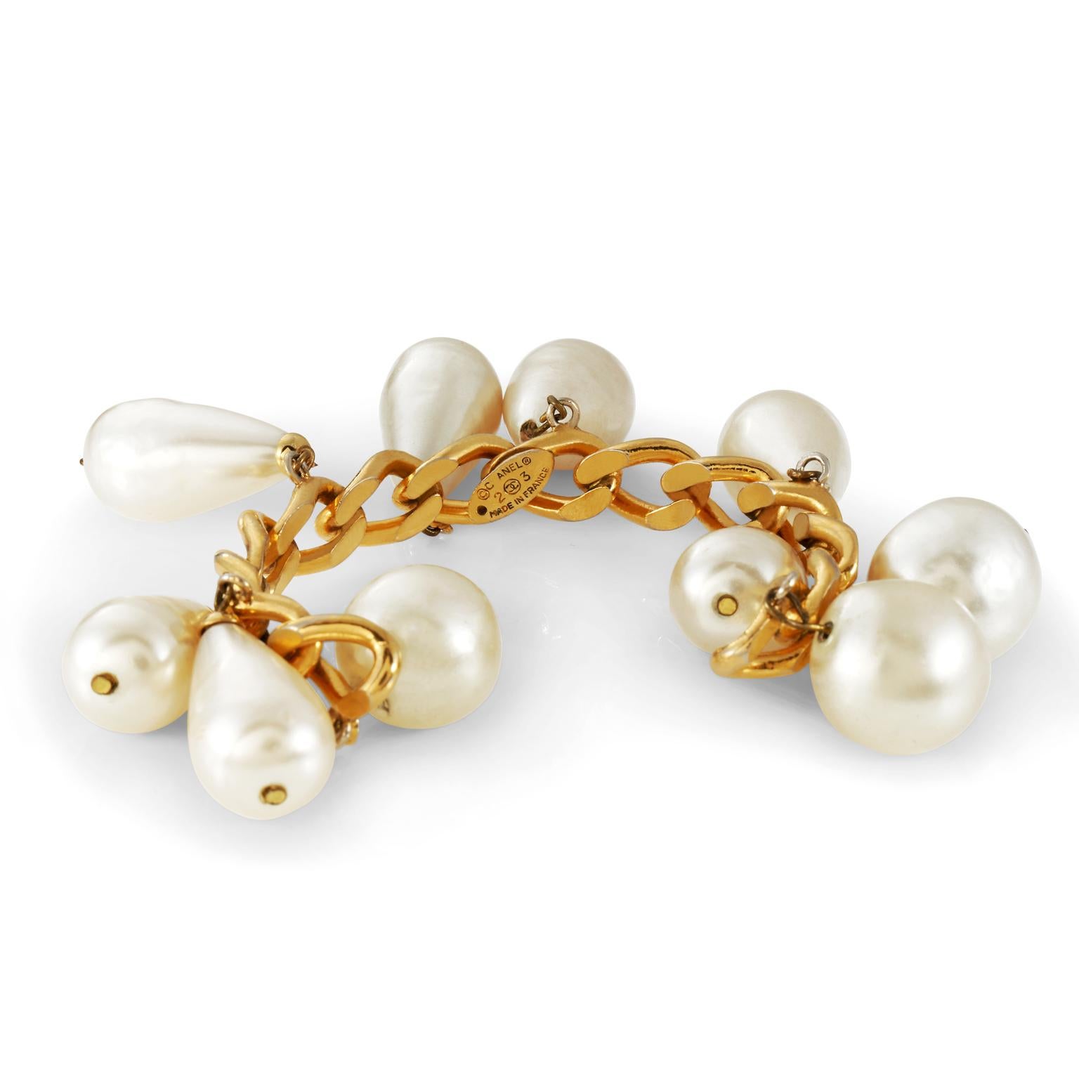 This authentic Chanel Gold Pearl Drop Cuff is in very good vintage condition from the mid 80’s.  Faux pearls dangle from a cuff of substantial gold links.  Open cuff style. Made in France.  Pouch or box included.

