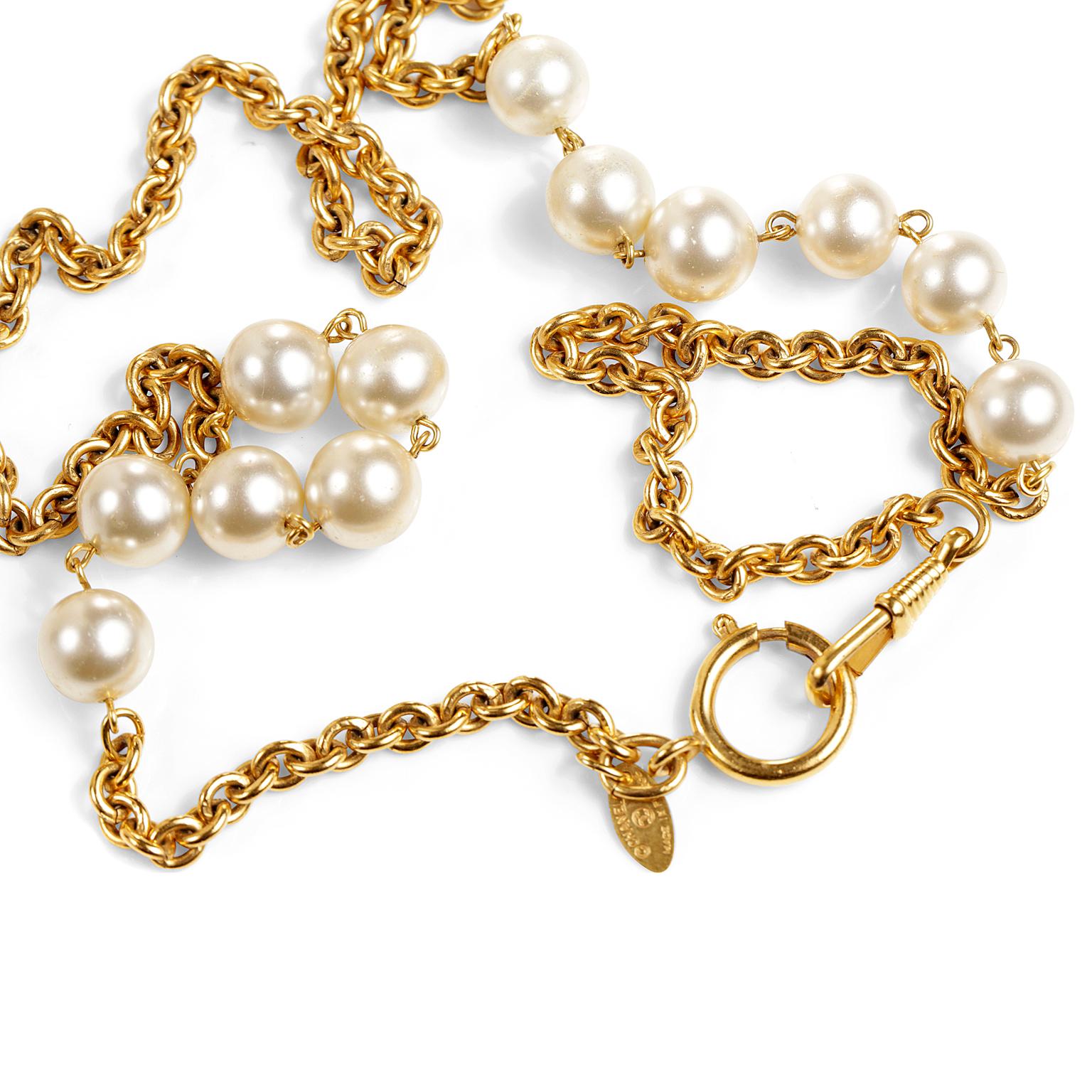 This authentic Chanel Gold and Pearl Station Necklace is in excellent condition.  Produced in the 1980’s, this piece holds its value and remains ever stylish.
Long gold link necklace has elegant faux pearl stations on either side.  Five pearls per