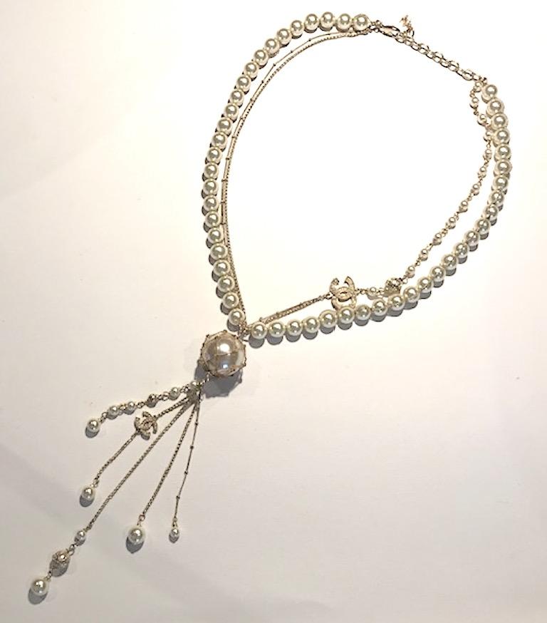 A very very nice multi strand Chanel necklace from the 2018 cruise collection. The single strand of 10 mm faux pearls is woven with a fine gold stand. One side of the necklace has a second 5mm pearl strand with a .88 of an inch wide and .63 of an