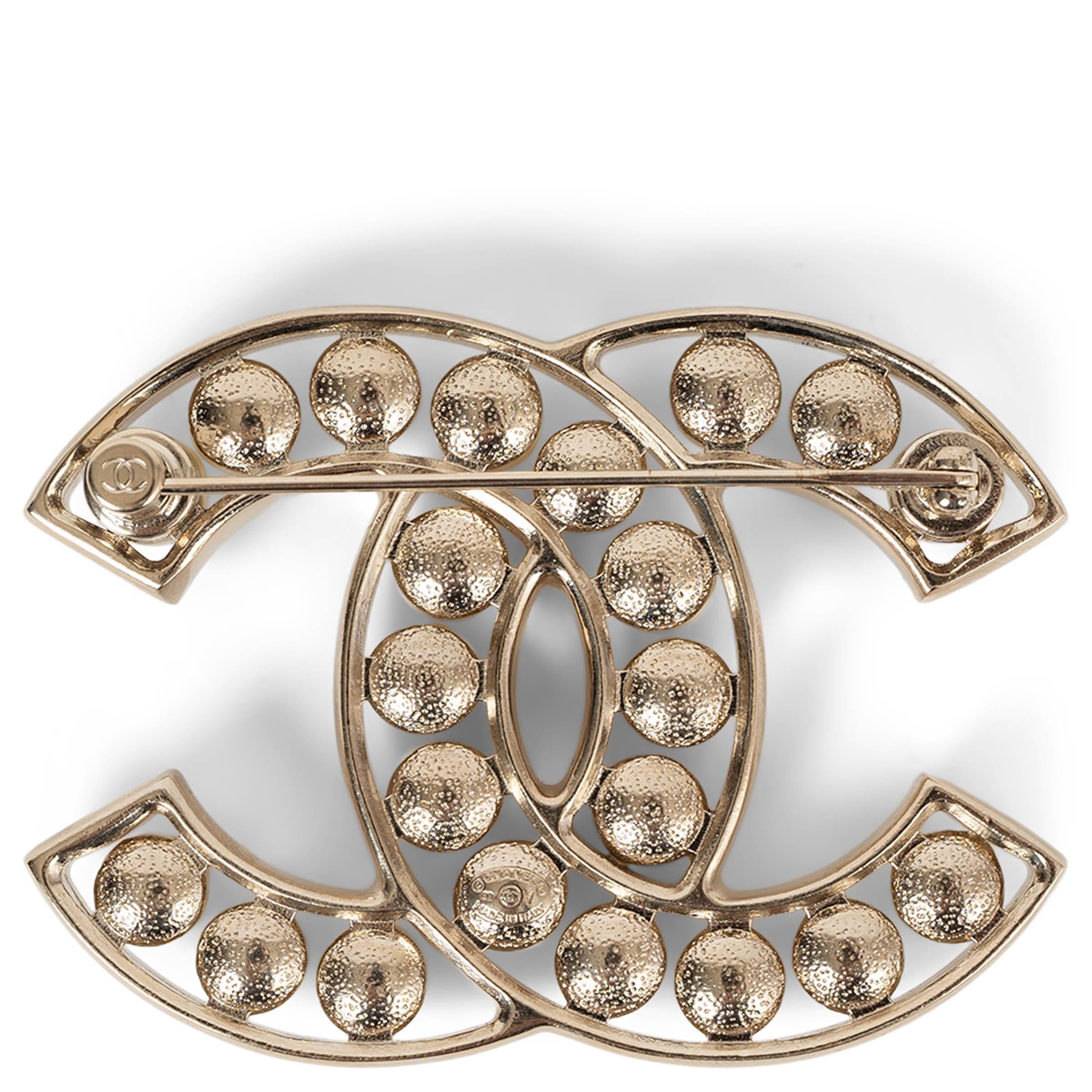 Cette broche CC 100% authentique de Chanel en métal doré beige est une expression raffinée de l'élégance intemporelle de la maison. Whiting, une rangée de perles cabochons flottantes en résine blanc nacré, crée un contraste délicat mais saisissant