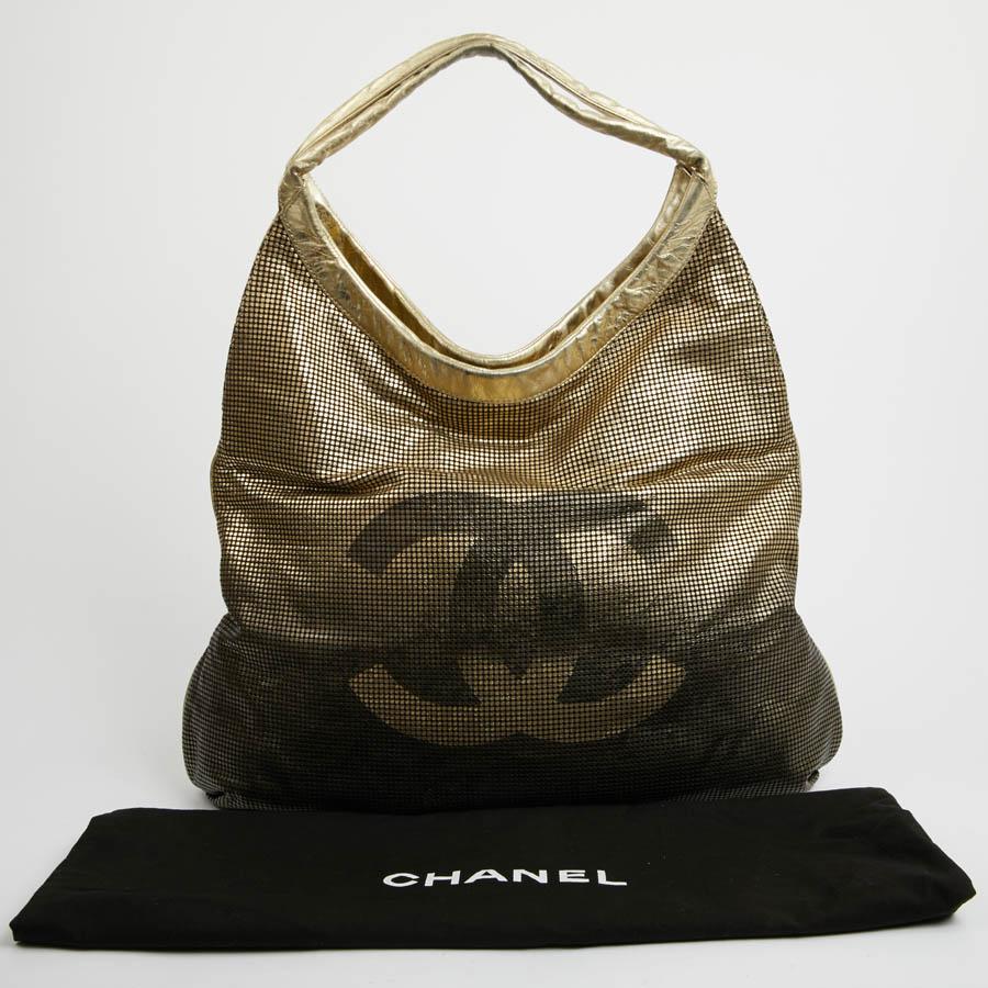 This large CHANEL second hand bag is gold grade. It is laser perforated leather. It's a limited edition. It is lined in smooth golden leather and gold satin. It has two large pockets, one zipped. On the front of the bag a large 