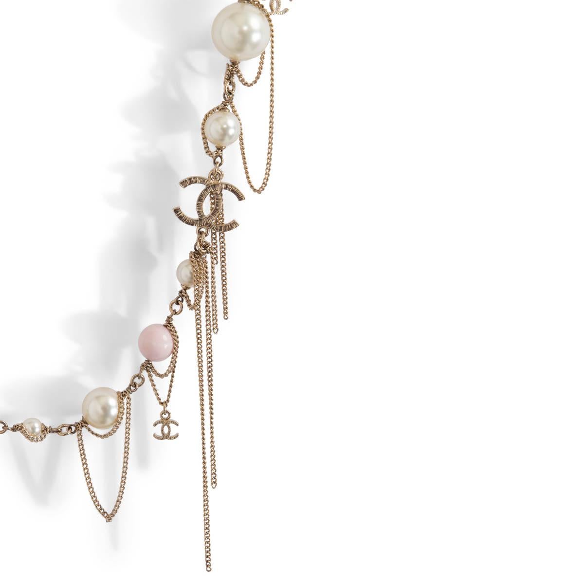 100% authentic Chanel chain necklace in gold-plated metal with CC charm embellished draped chain loops and alternating Gripoix glass beads in semi- transparent and opaque pink, and faux pearls. Ranging from 12mm tp 15mm. Closes with large lobster