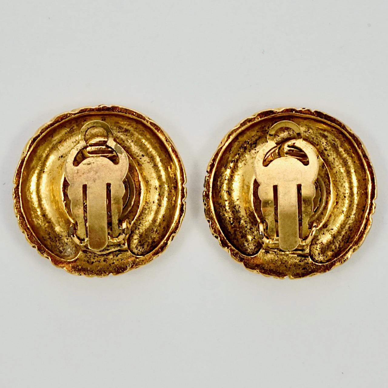 Fabuleuses boucles d'oreilles Chanel en plaqué or, avec le logo Chanel entouré d'un motif strié. Diamètre de mesure 2,7 cm / 1 pouce. La dorure est légèrement usée.

Ces magnifiques boucles d'oreilles de Chanel datent des années 1970.
