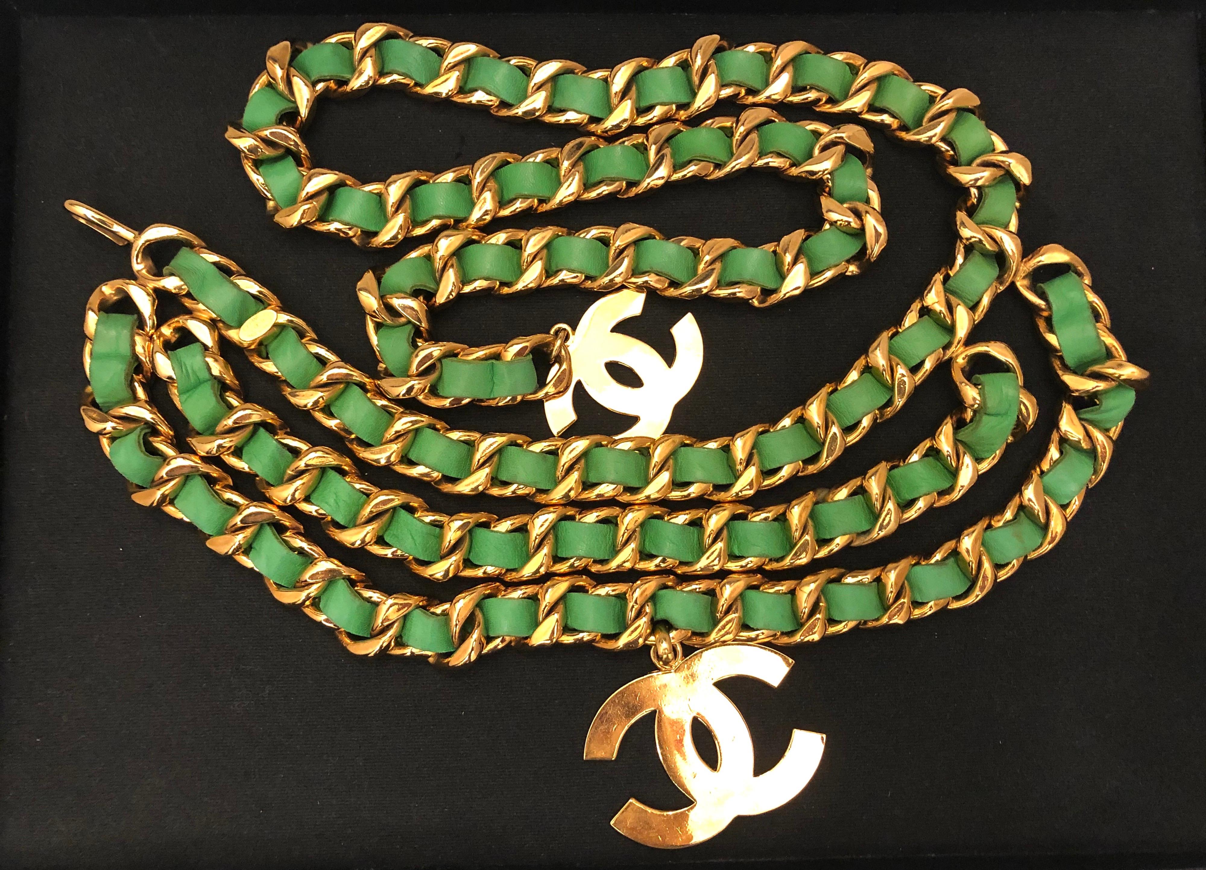 Early 1990s Chanel chunky chain belt has a triple chain front interlaced with green leather featuring two large CC charms. Total length of 10 cm (39.5 inches) Charms measure 4.2 x 6.3cm and 3.3 x 5cm. Adjustable hook fastening. It can be worn as a