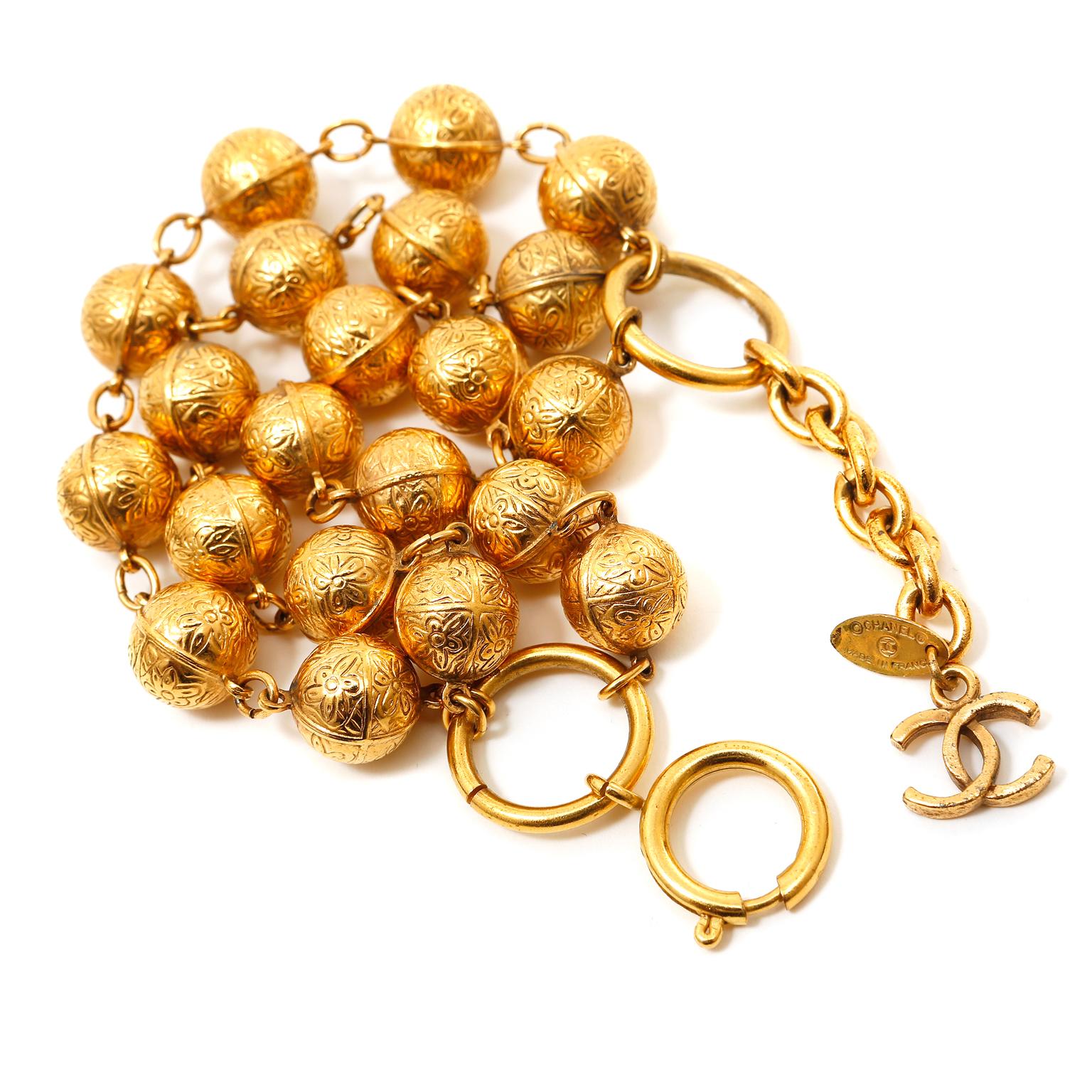 This authentic Chanel Gold Plated Triple Strand Bracelet is in excellent condition from the early 1980's.  Three strands of gold-plated flower engraved beads are strung together for a layered look.  Adjustable length 7