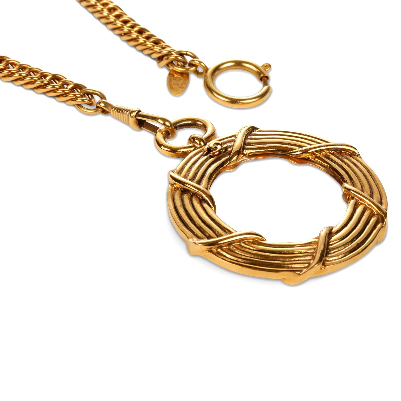 This authentic Chanel Gold Rope Magnifier  Necklace is in excellent vintage condition from the late 1980’s.   Large gold tone circular magnifier pendant dangles from a long linked chain.   Approximately 34 inches, pendant approximately 2 inches. 