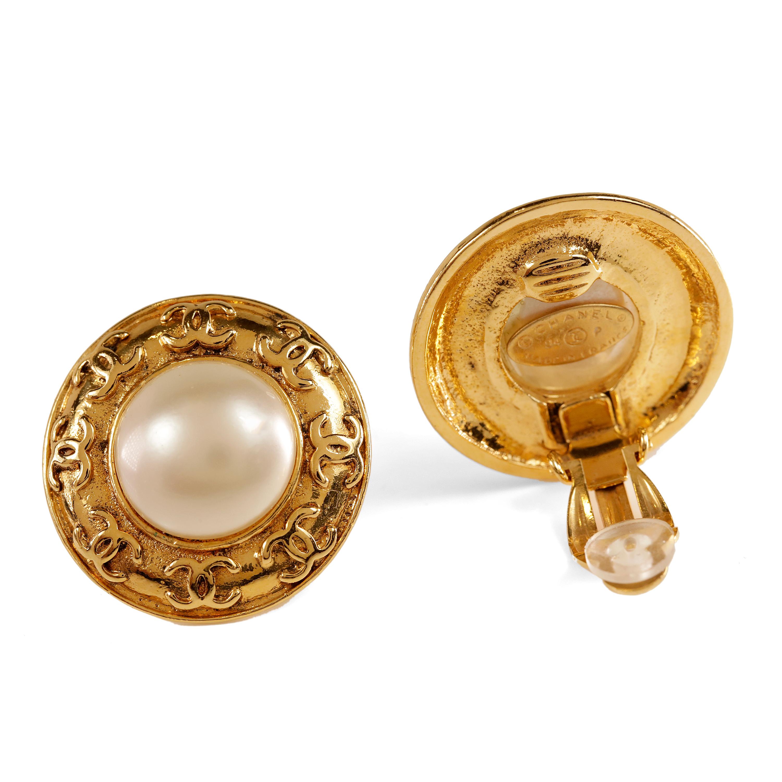 These authentic Chanel Gold Pearl Clip On Earrings are in excellent vintage condition.  From the 1994 collection, they feature a round faux pearl surrounded by gold interlocking CC border. Clip on closure.  Made in France.  

