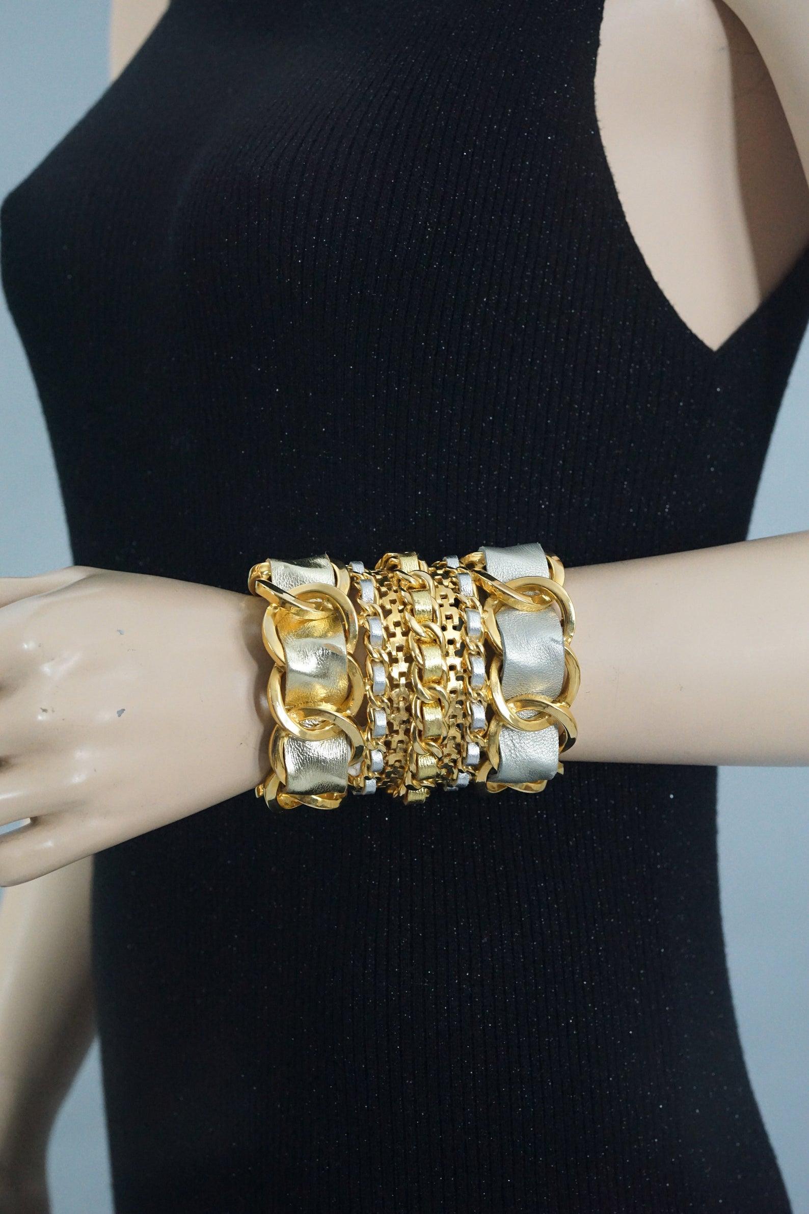 Features:
- 100% Authentic CHANEL.
- Massive chain cuff bracelet with woven gold and silver leather.
- Rigid wide cuff.
- Gold tone.
- Signed with CHANEL 2 CC 6 Made in France.
- Will fit small to medium wrists.
- Excellent vintage