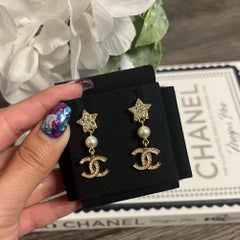 Boucles d'oreilles pendantes CHANEL « Gold Star » en cristal CC et fausses perles