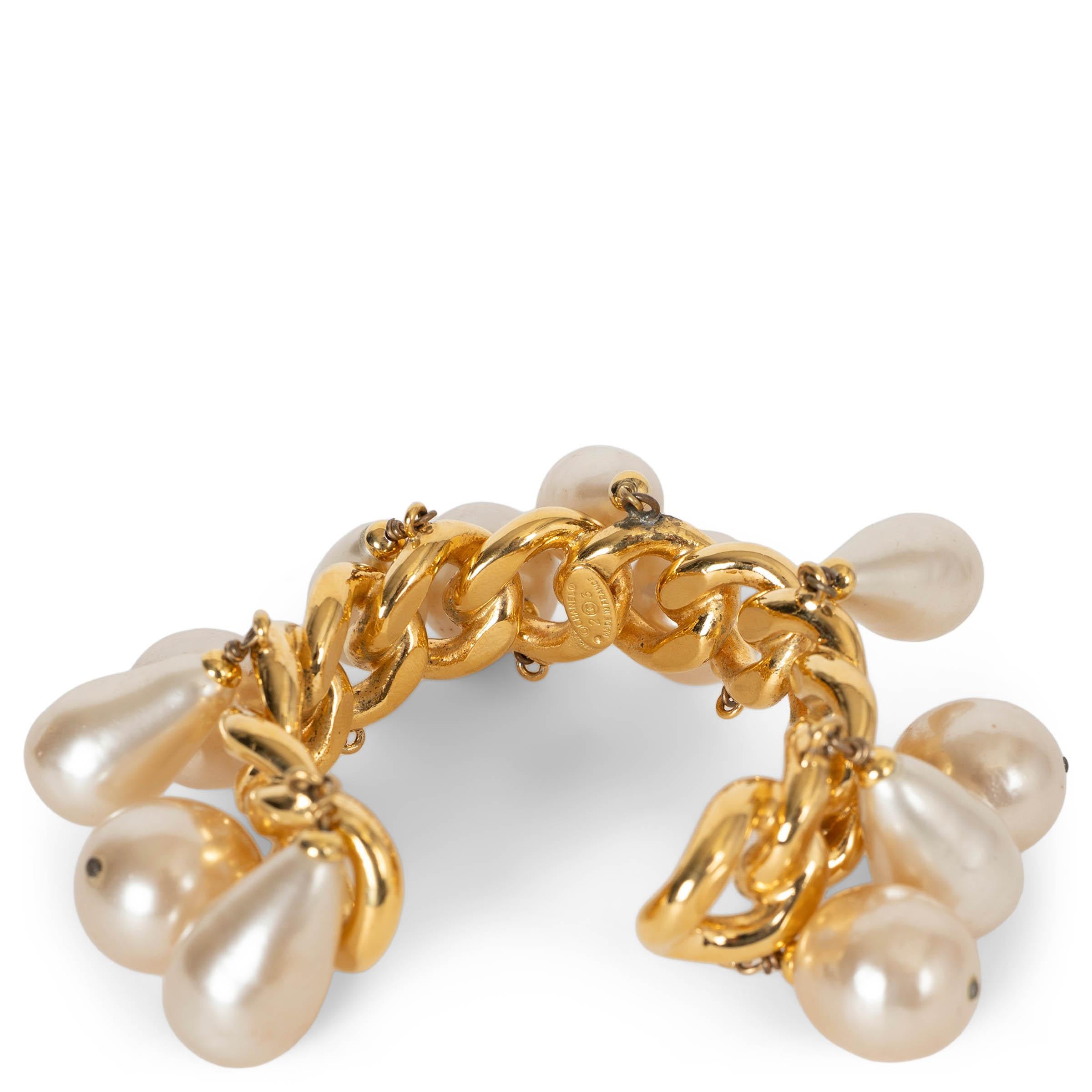 These 100% authentic Chanel cuff bracelet is crafted in a bold, high-shine gold-plated chain and adorned with an array of dangling pearly white imitation pearls in both round and drop shapes. A striking, movement-filled statement piece that captures