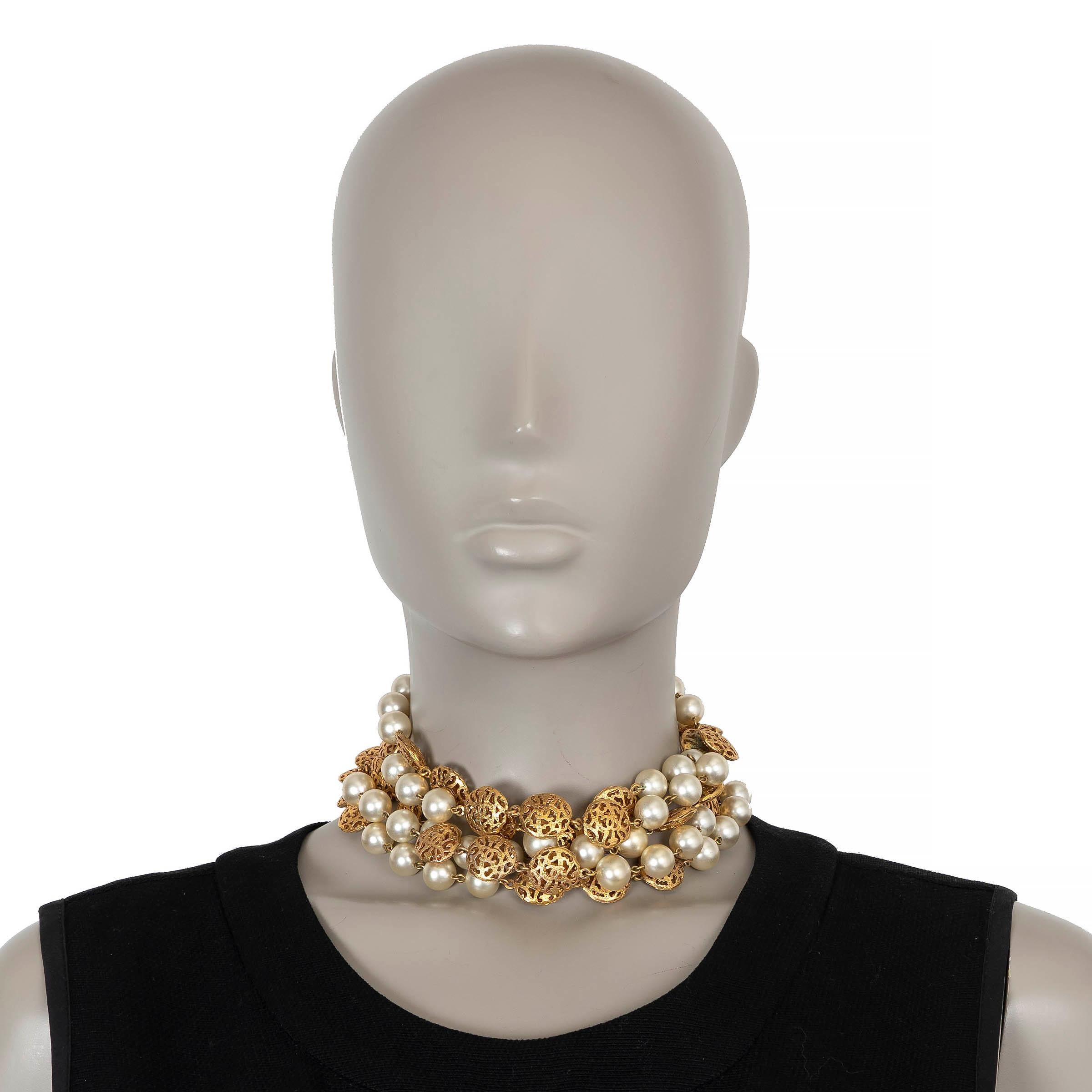 This 100% authentic Chanel cocker features multiple cascading strands of pearly white imitation pearlsintertwined with gold-tone metal filigree beads, each delicately sculpted and finished with subtle CC motifs. A beautifully intricate piece that