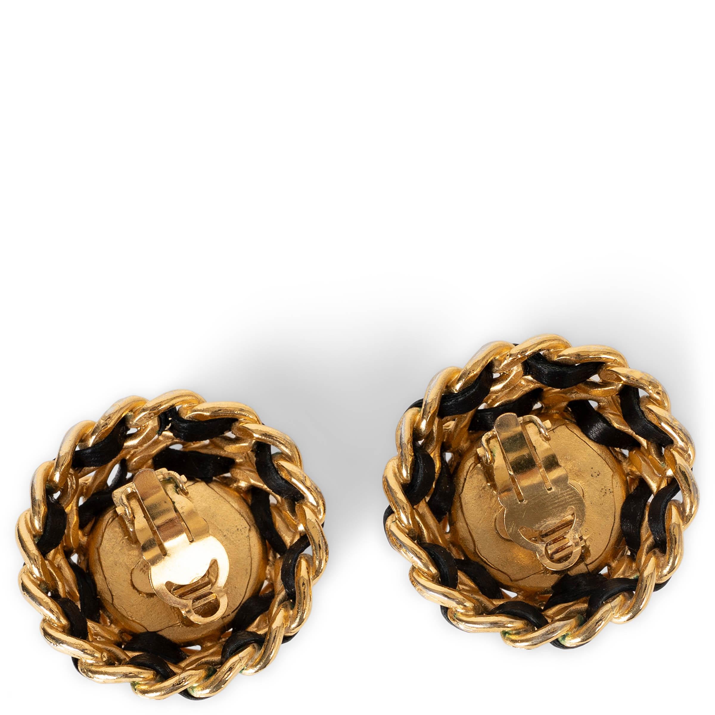 These 100% authentic Chanel clip-on earrings feature a luminous pearly white imitation pearl wrapped in the house’s iconic gold-tone double chain interwoven with black leather. A timeless and highly collectible design that captures the essence of