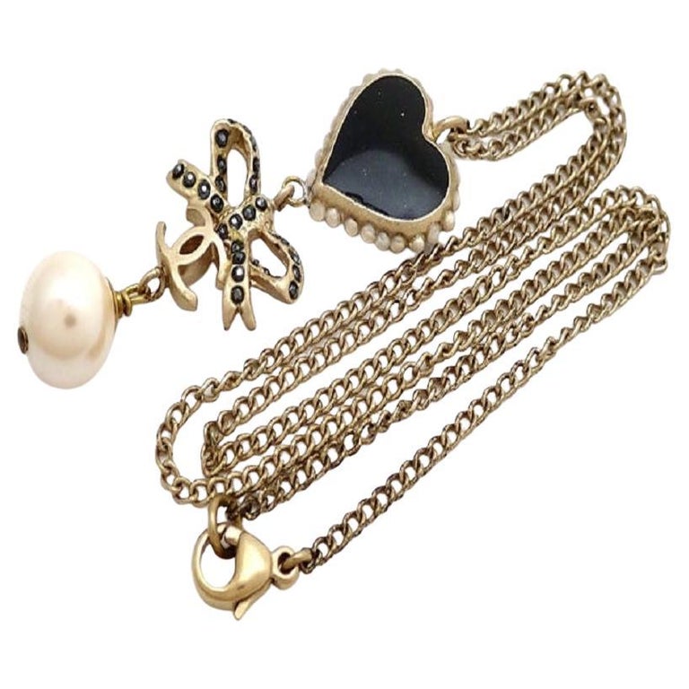 Chanel Goldtone Black Heart Ribbon Pendant CC Necklace For Sale at 1stDibs