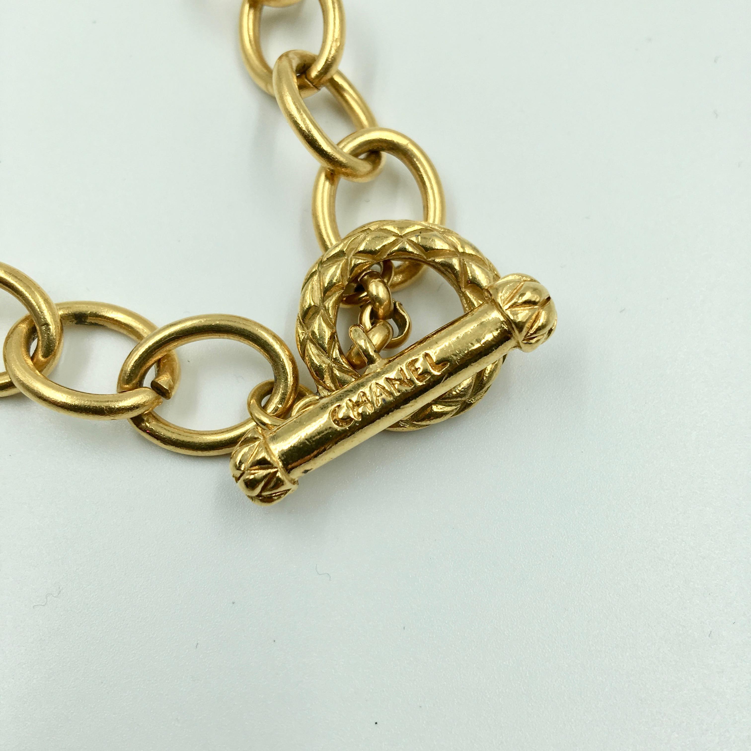 Chanel, collier croix tourbillonnante avec logo CC, couleur or Bon état - En vente à Los Angeles, CA