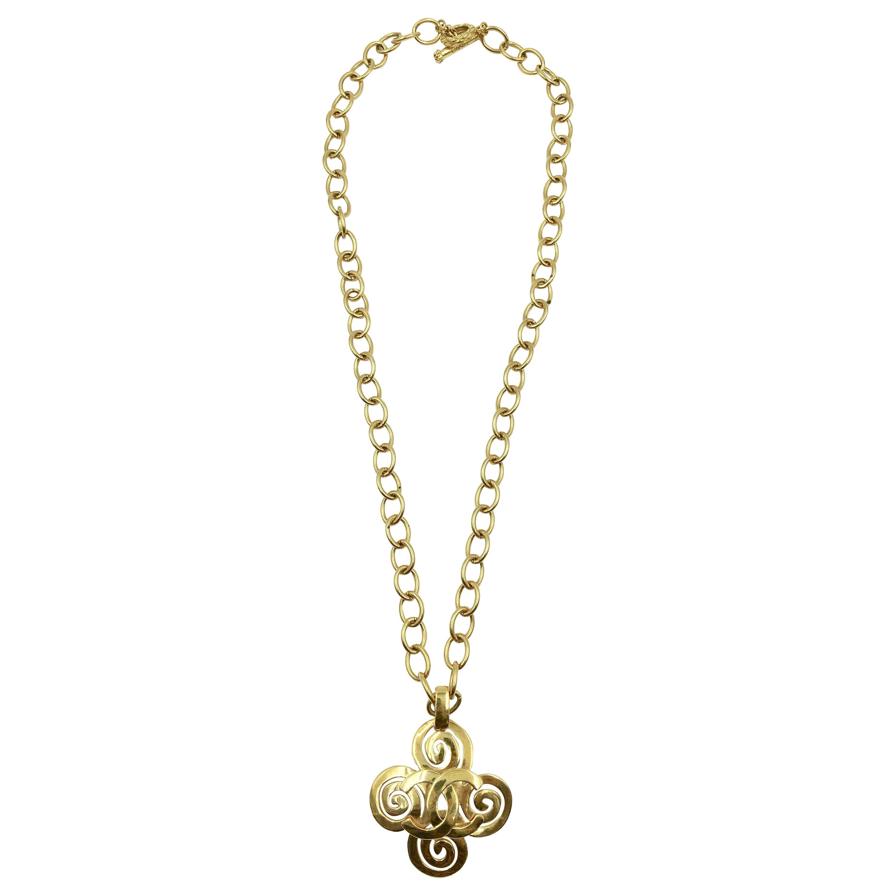 Chanel, collier croix tourbillonnante avec logo CC, couleur or en vente