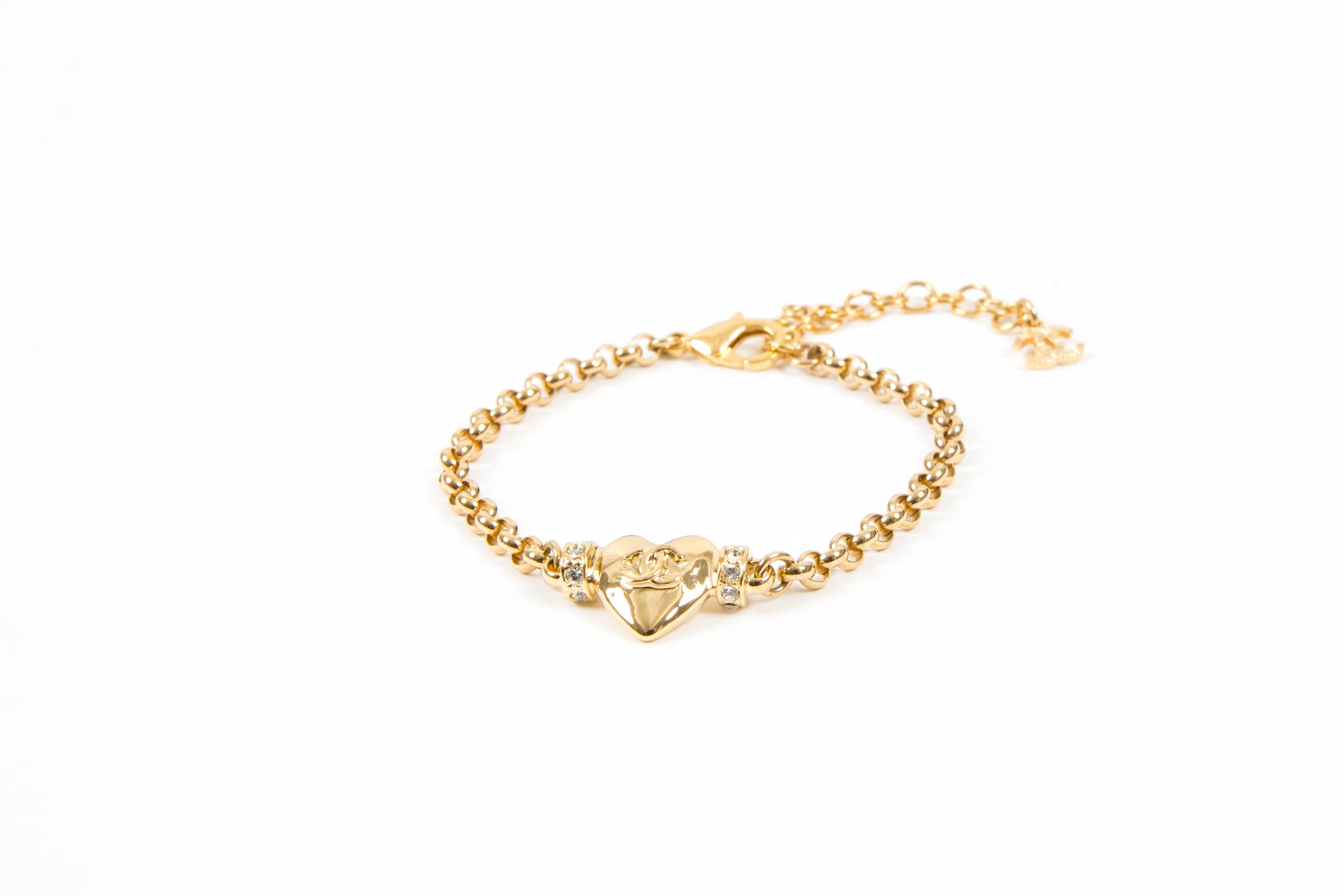 Chanel gold-tone heart bracelet featuring a front gold-tone heart with white strass,  adjustable length, a free back CC ;plaque pitted on the spring ring closure
Circa 2000s . Made in France
Maxi Length: 9.05in. (23cm)
Width: 0.6in (1.5cm)
Good
