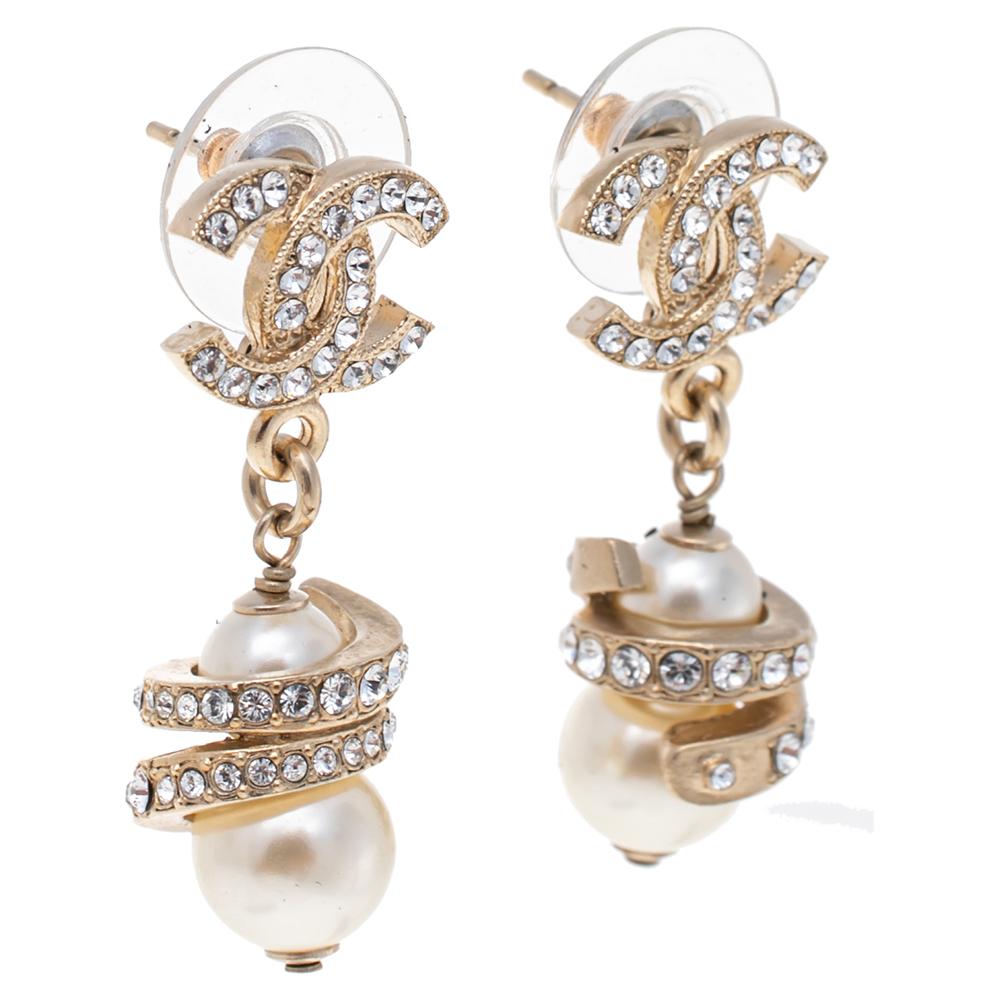 These drop earrings from Chanel exude an alluring appeal and are absolutely eye-catching! They have been crafted from gold-tone metal and designed with the iconic CC logo flaunting pearl drops that dangle elegantly. They are enhanced with crystal