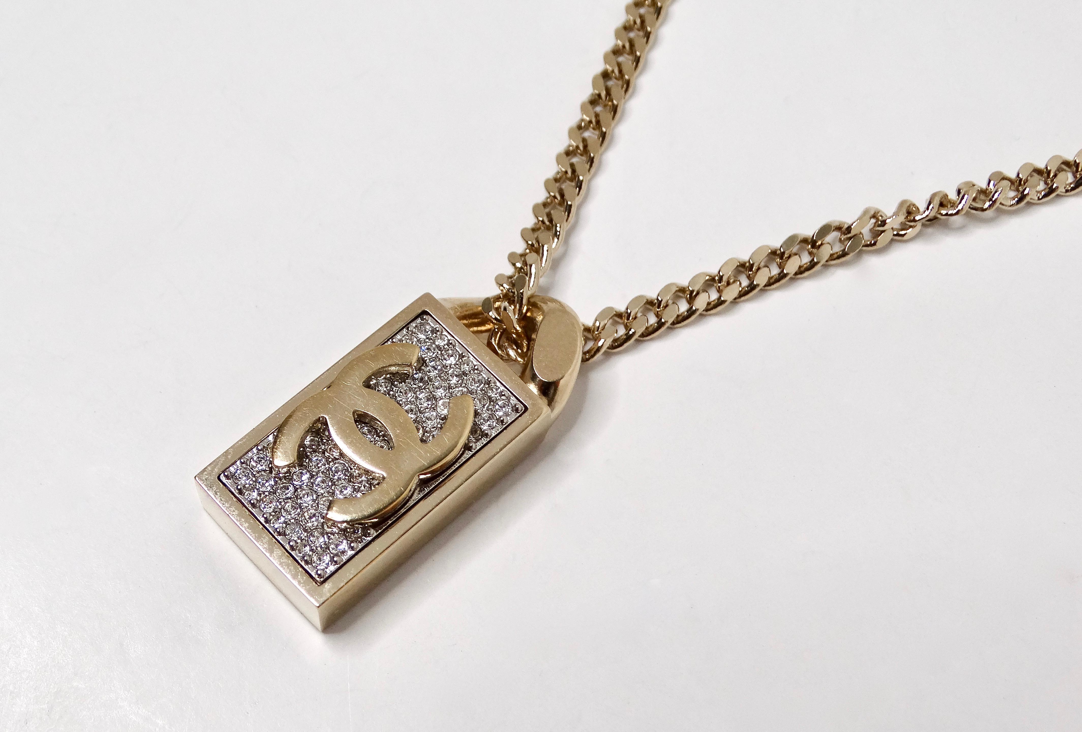 Le collier de chaîne à pendentif de style étiquette de chien en cristal doré de Chanel est une pièce époustouflante qui incarne parfaitement l'élégance et le luxe caractéristiques de la marque. Réalisé avec une attention méticuleuse aux détails, ce