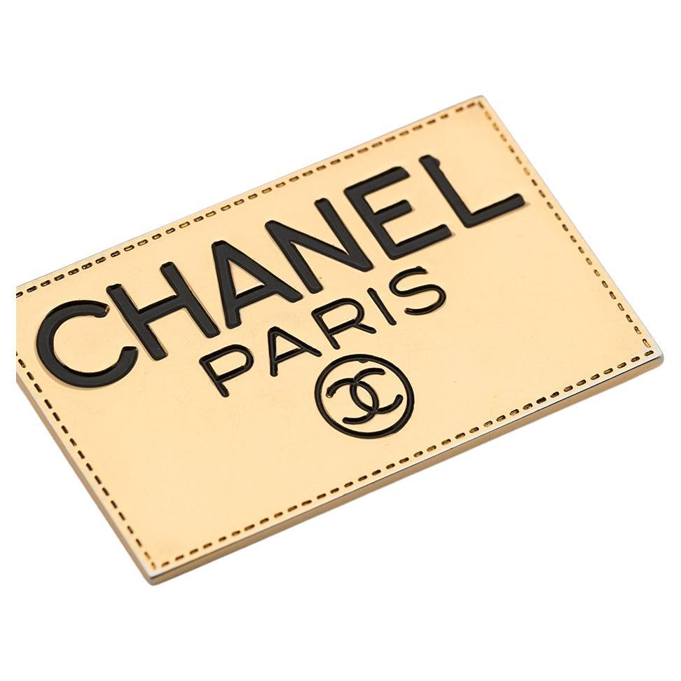 Chanel gold-plated logo-engraved plate brooch featuring a front black engraved, back engraved logo to the rear, bar-pin fastening. 
Circa 1990s . Made in France
Length: 1.9in. (5cm)
Width: 1.18in. (3cm) 
Good vintage condition. Made in France.  
We