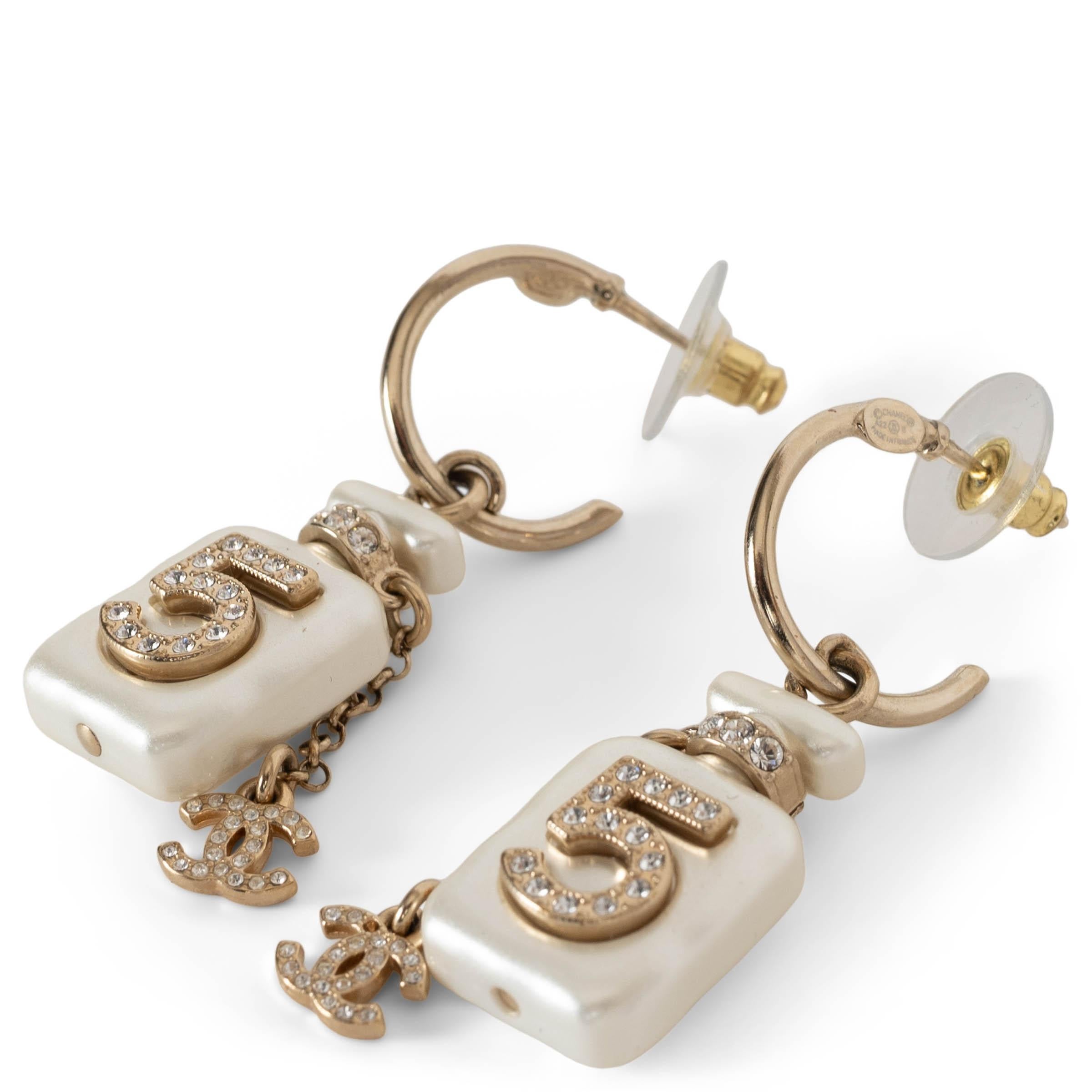 This 100% authentic pair of Chanel pearl resin crystal embellished CC No.5 perfume bottledrop earrings is a dazzling homage to Chanel’s iconic legacy. In a sophisticated light gold-tone and pearly white finish, each earring features a