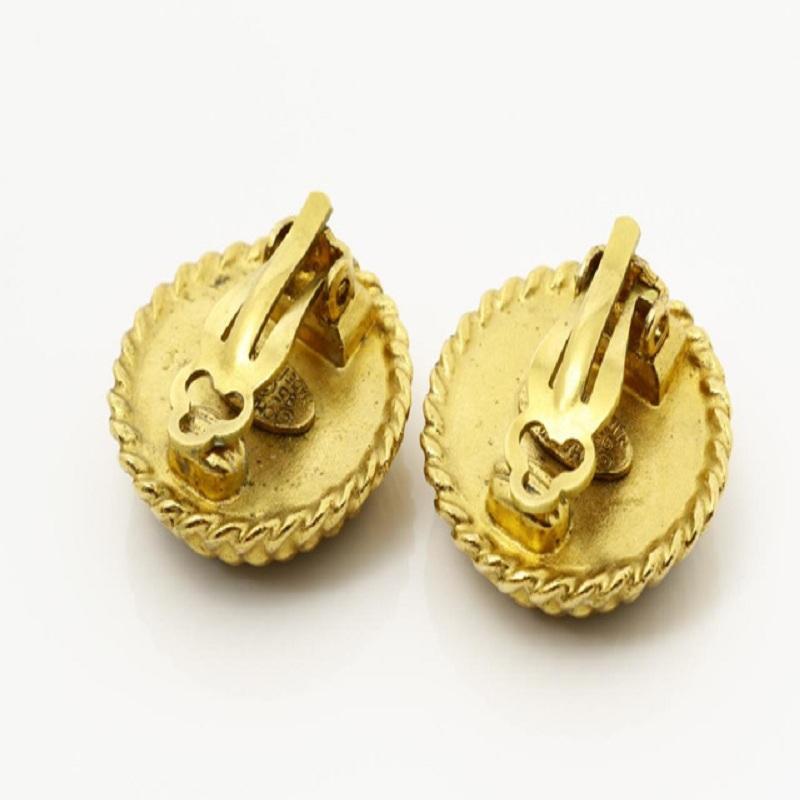 Les boucles d'oreilles CC Vintage Chanel sont dotées d'un matériel en métal doré, d'un émail noir rond sur le devant avec le logo CC entrelacé sur le dessus et d'une fermeture à clip.


72665MSC