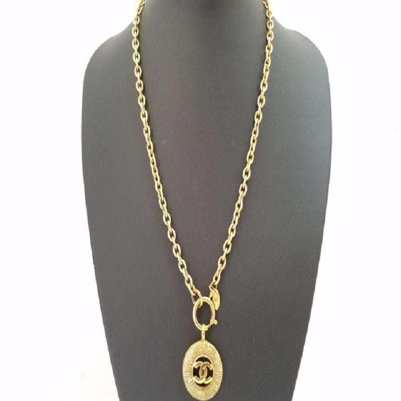 Chanel Classic necklace features gold-tone chain, a circular sunburst pendant housing a cutout interlocking CC logo and an oversize O-ring clasp closure.

72650MSC