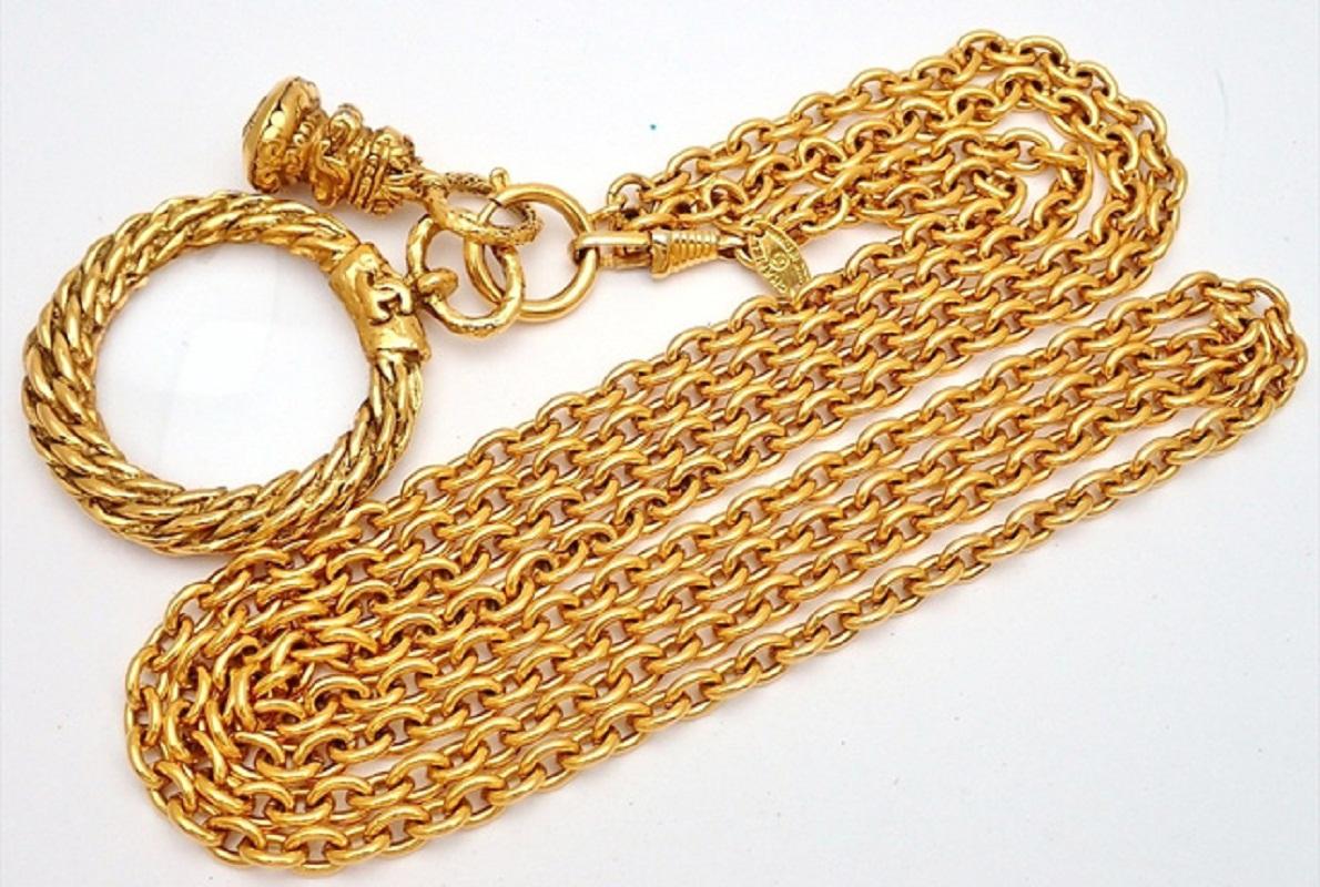 Chanel Loupe necklace features gold-tone hardware, a round magnifying glass pendant with a braided detail frame, an interlocking CC logo on the top center, a spring-ring closure. 