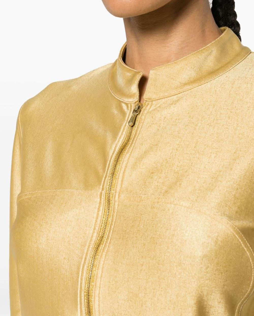 200&, Chanel gold-tone metallic unlined cropped jacket featuring a cropped length, a strech gold-tone jersey fabric,  a metallic finish, a mock neck, a front zip fastening, long sleeves.
Composition: Nylon 80%, Spandex/Elastane 20%
Circa