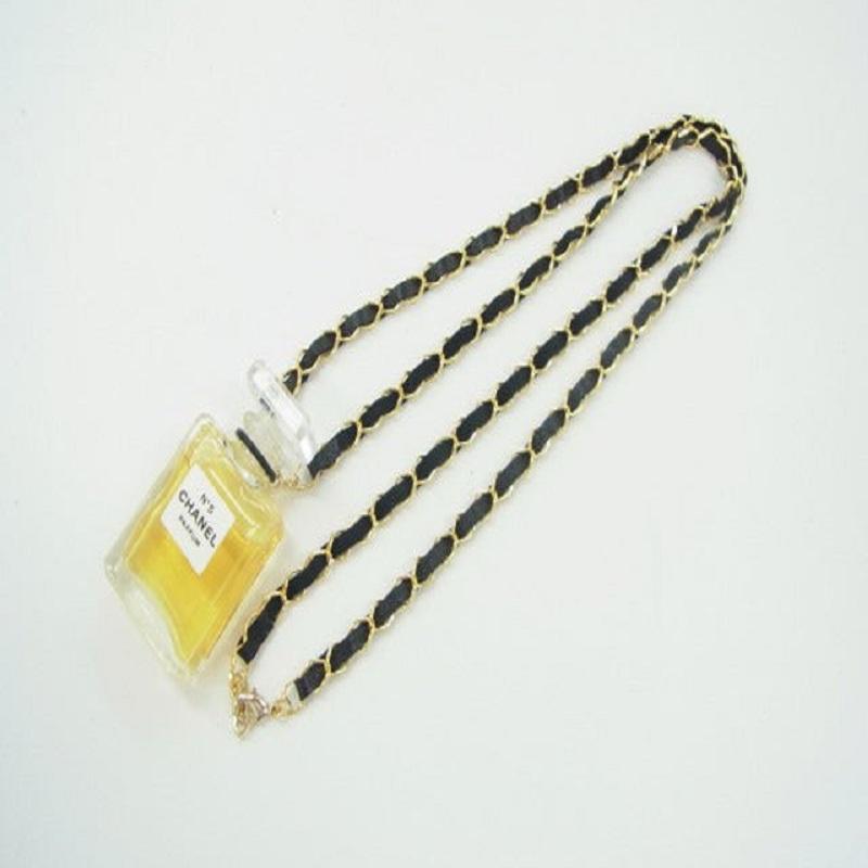 Chanel Necklace features gold-tone chain entwined with black leather, a small Chanel No.5 perfume bottle pendant and lobster clasp closure.
 

57581MSC