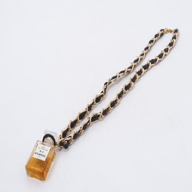 Chanel Necklace features gold-tone chain entwined with black leather, a small Chanel No.5 perfume bottle pendant and lobster clasp closure.
 

57083MSC