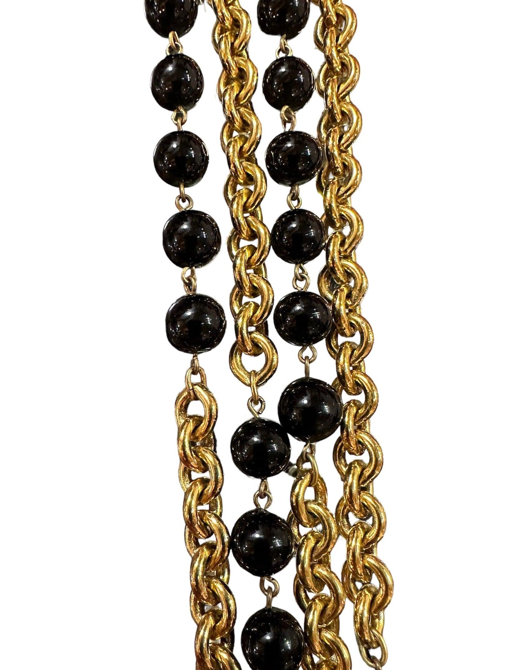 Collier à double maille emblématique de Chanel en ton or. Datée de 1984, cette pièce présente deux fils d'or étincelants avec des perles noires intercalées. Portez-le pour toujours comme une pièce d'héritage intemporelle, parfaite pour les