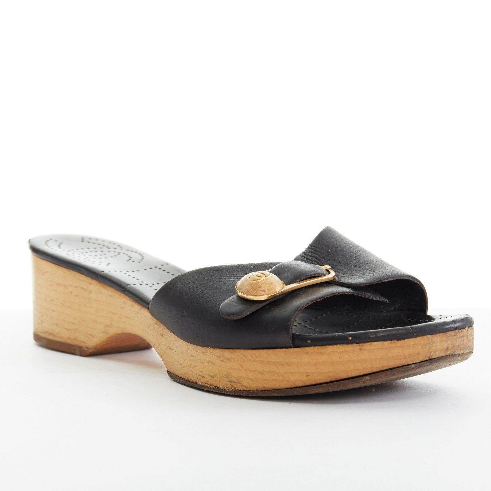 CHANEL gold wooden CC buckle black leather wooden platform clog sandals 8B EU38

CHANEL
Black leather upper. Gold-tone metalwith wooden CC buckle detail. Open toe. Wooden platform heel. Black leather lining with perforated quilting and CC logo. Clog