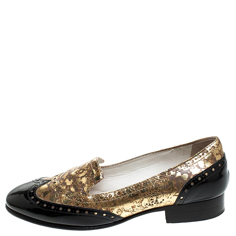 Breathtakingly beautiful, these loafers from Chanel look straight out of a dream! Shimmering in metallic gold and black, the loafers are crafted from patent and textured leather. They flaunt comfortable leather-lined insoles and low