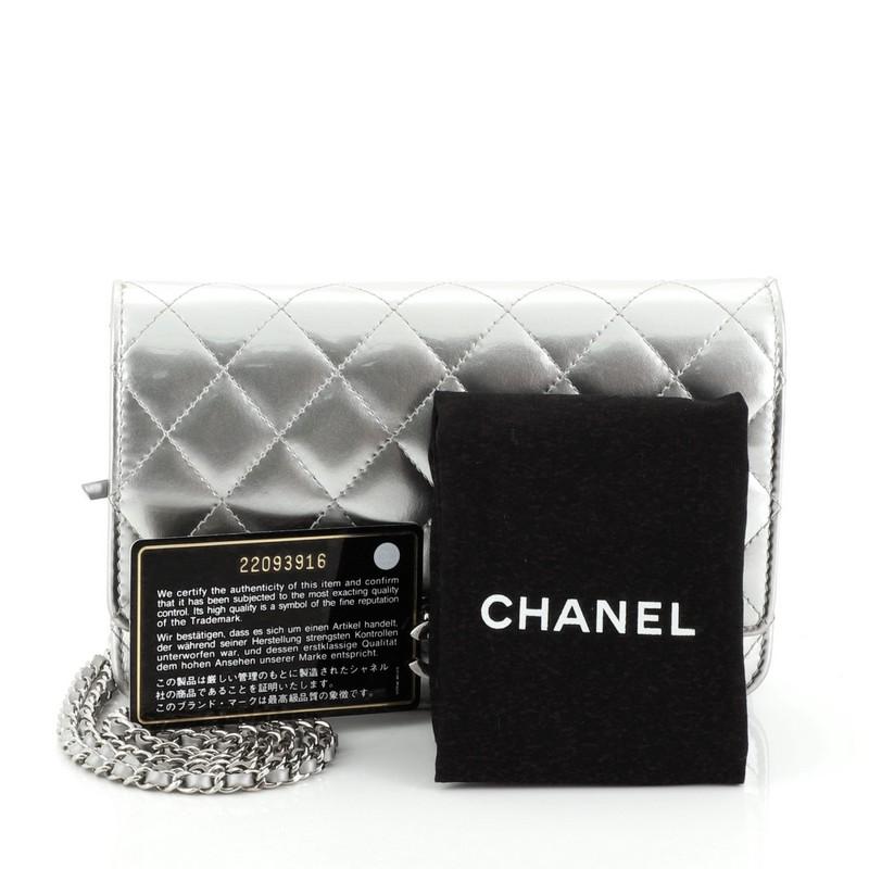 This Chanel Golden Class Wallet on Chain Quilted Patent, crafted in silver quilted patent leather, features woven-in leather chain strap and silver-tone hardware. Its CC flip clasp closure opens to a gray leather interior with side zip and slip