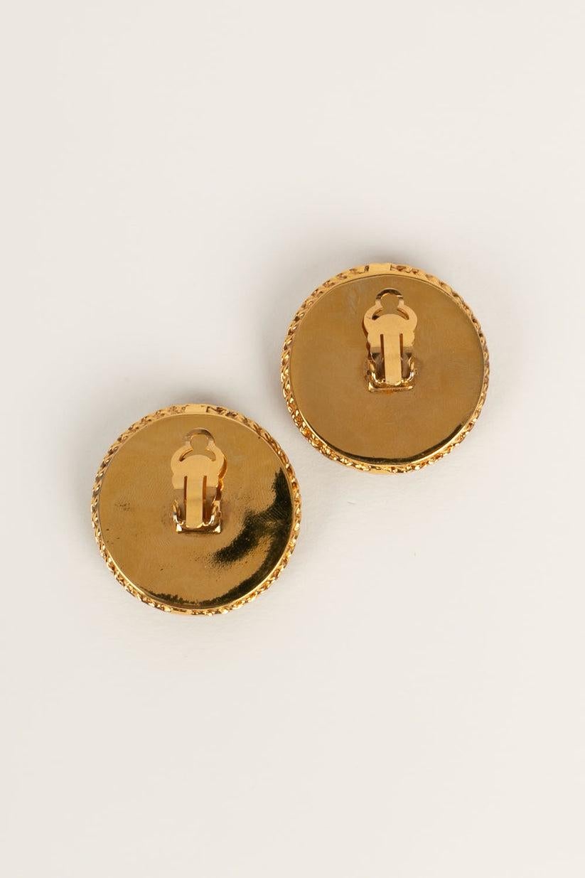Chanel -Ohrringe mit Clip aus goldenem Metall und Bakelit.

Zusätzliche Informationen:
Abmessungen: Ø 4 cm
Zustand: Sehr guter Zustand
Verkäufer Ref Nummer: BOB126