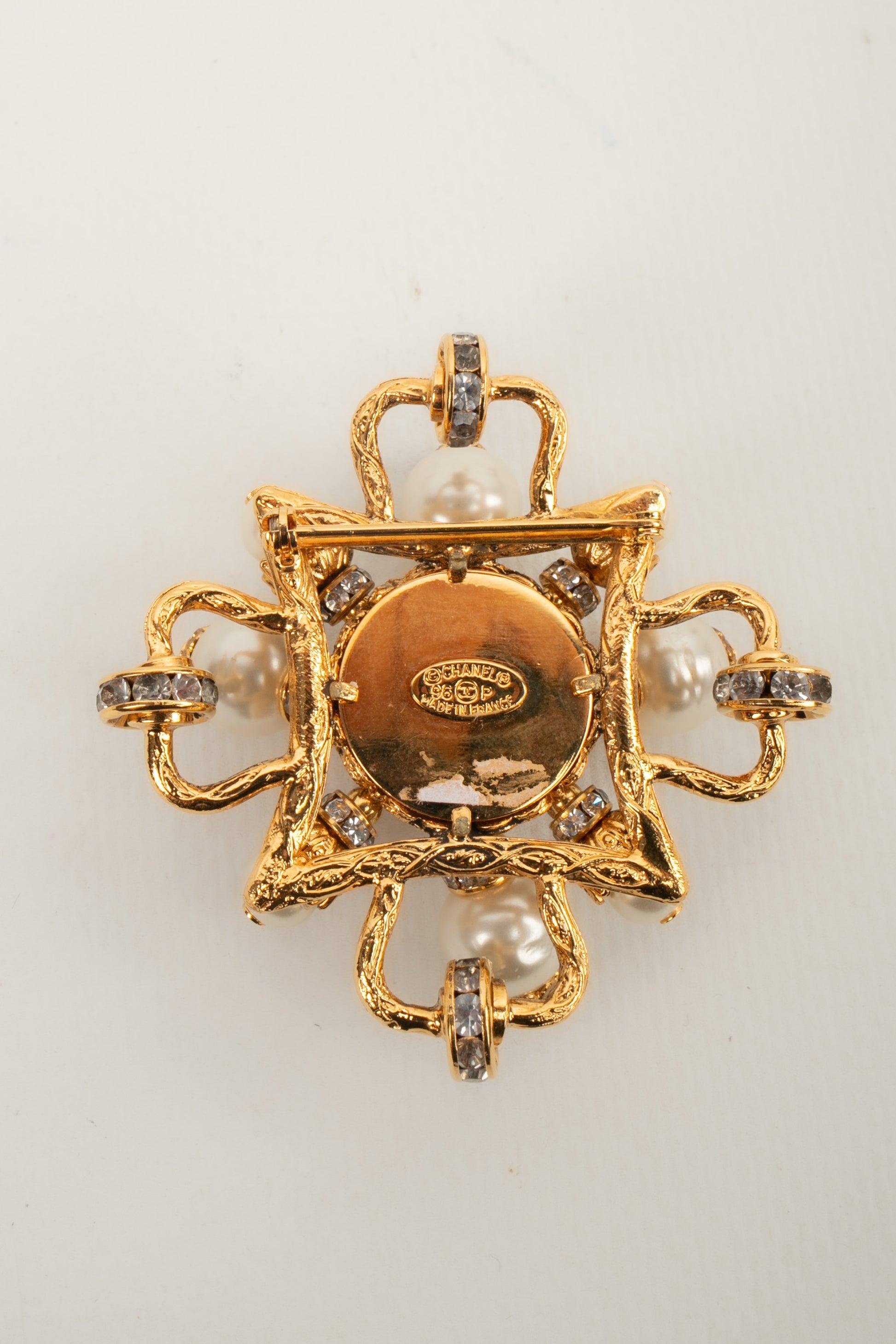 Chanel - (Made in France) Golden metal brooch with costume pearls and rhinestone rings. 1996 Spring-Summer Collection.

Additional information:
Condition: Very good condition
Dimensions: Height: 6 cm
Period: 20th Century

Seller Reference: BRB158
