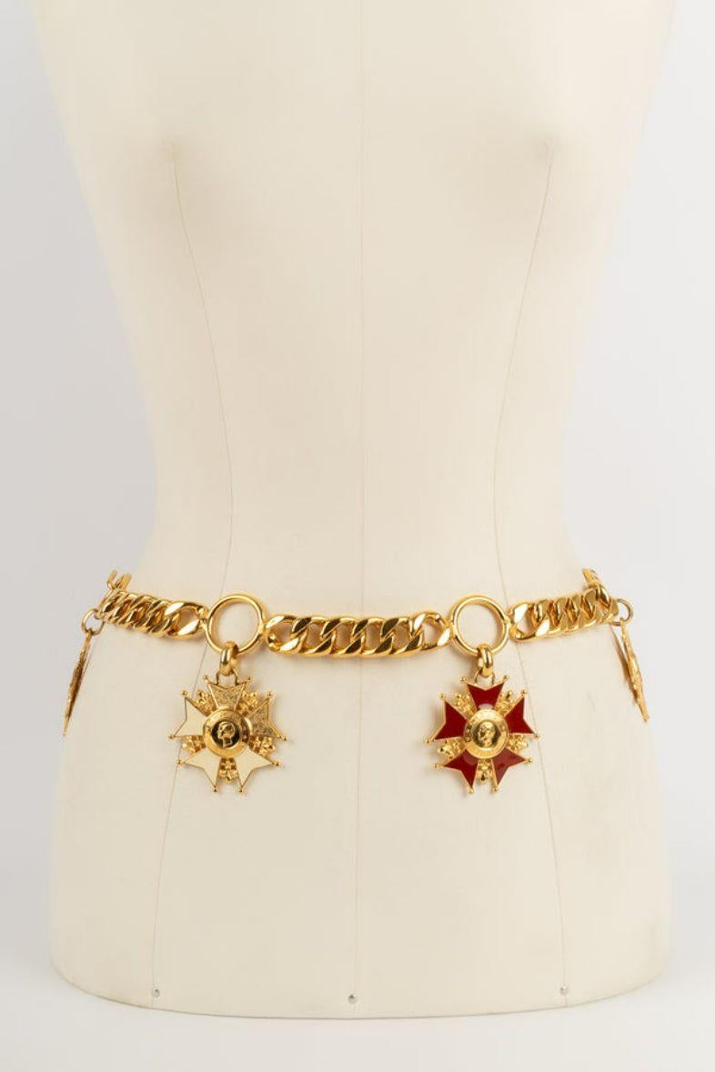 Chanel -Golden metal belt and multicolored enamel. To note, the enamel is missing on one of the crosses.

Additional information: 
Dimensions: Length: 69 cm
Condition: Good condition
Seller Ref number: CCB1