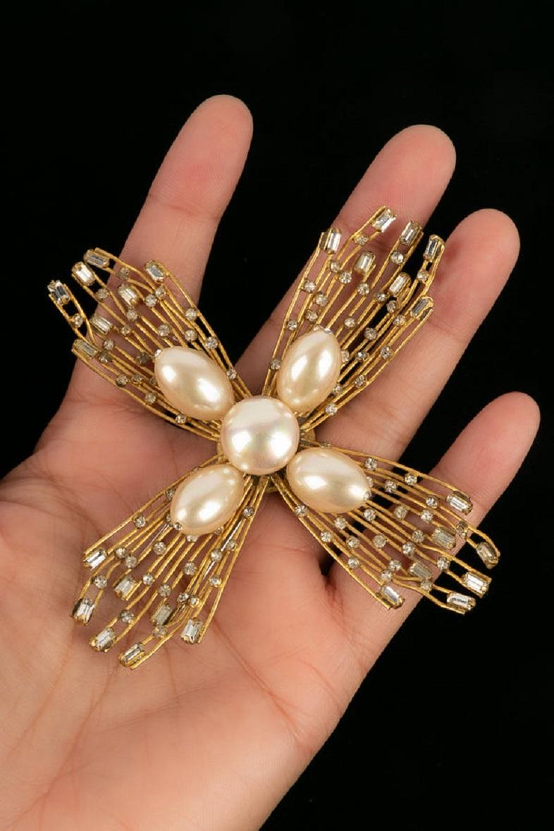 Chanel - Golden metal brooch, rhinestones and pearly beads.

Additional information:
Dimensions: 10 W x 10 H cm
Condition: Very good condition
Seller Ref number: BRB14