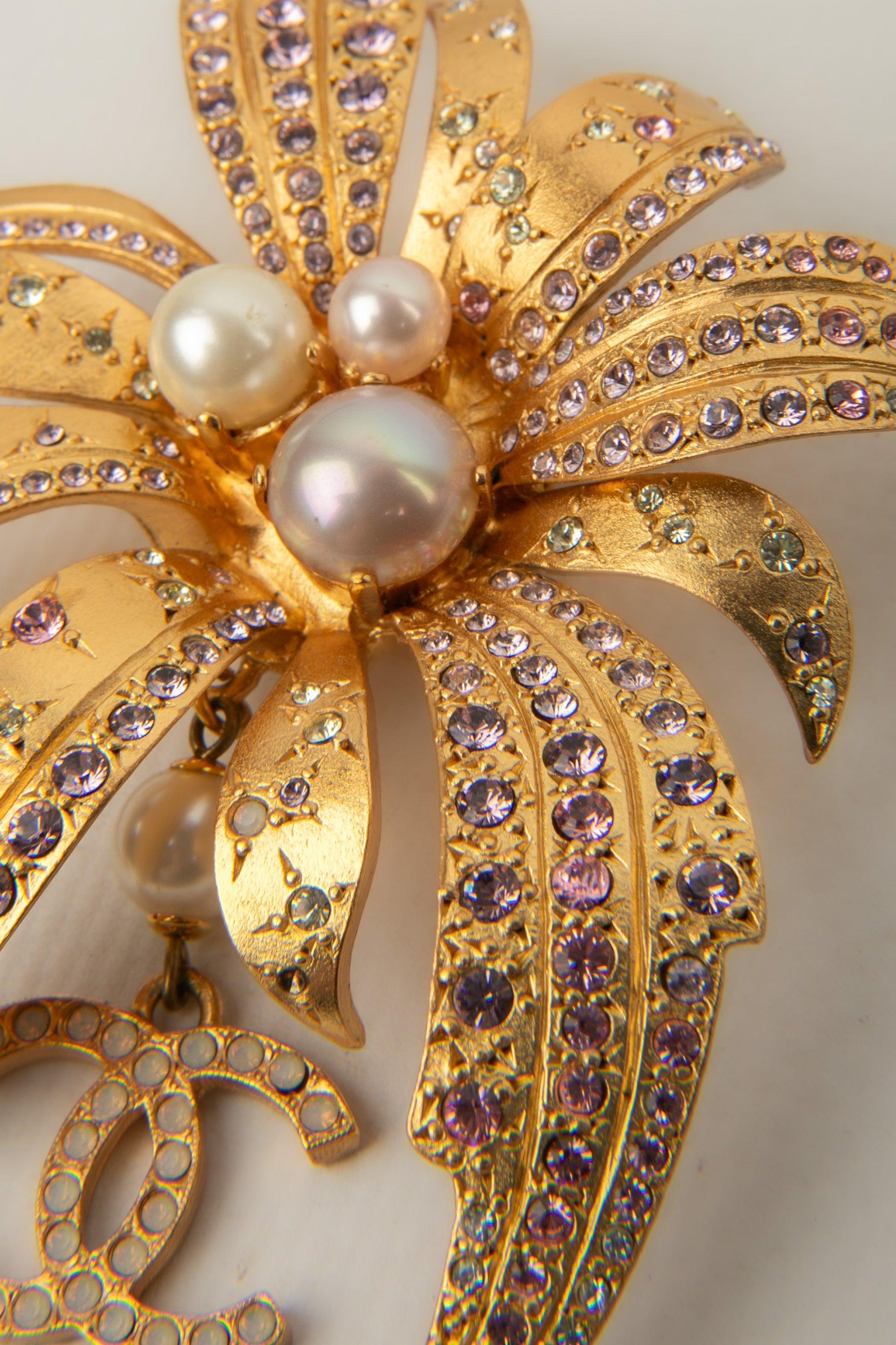 Chanel- (Made in France) Golden metal brooch ornamented with Swarovski rhinestones and costume pearls. 2002 Spring-Summer Collection.

Additional information:
Condition: Very good condition
Dimensions: Height: 9 cm
Period: 21st Century

Seller