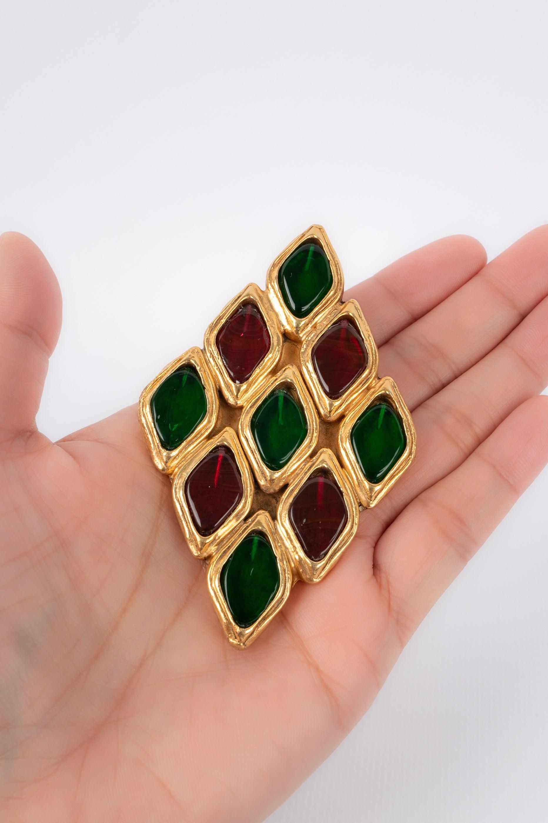 Chanel - (Made in France) Golden metal brooch with a diamond shape ornamented with red and green glass paste cabochons.

Additional information:
Condition: Very good condition
Dimensions: 8 cm x 5 cm

Seller Reference: BRB6