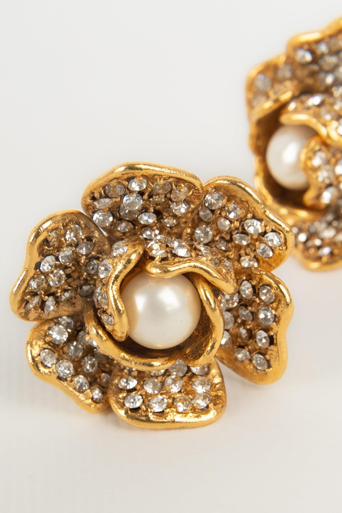 Chanel - (Made in France) Golden metal camellia earrings ornamented with rhinestones and a central pearly cabochon. Fall-Winter 1997 Collection.

Additional information:
Condition: Very good condition
Dimensions: Height: 4 cm
Period: 20th