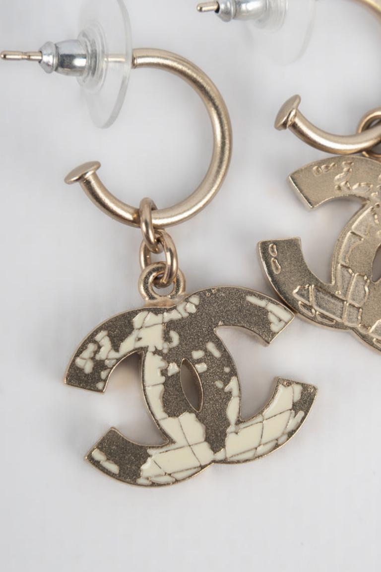Chanel - (Made in France)Very-light-golden metal earrings representing the cc logo enameled with beige. 2013 World Map Collection.

Additional information: 
Condition: Very good condition
Dimensions: Length: 3.6 cm
Period: 21st Century

Seller